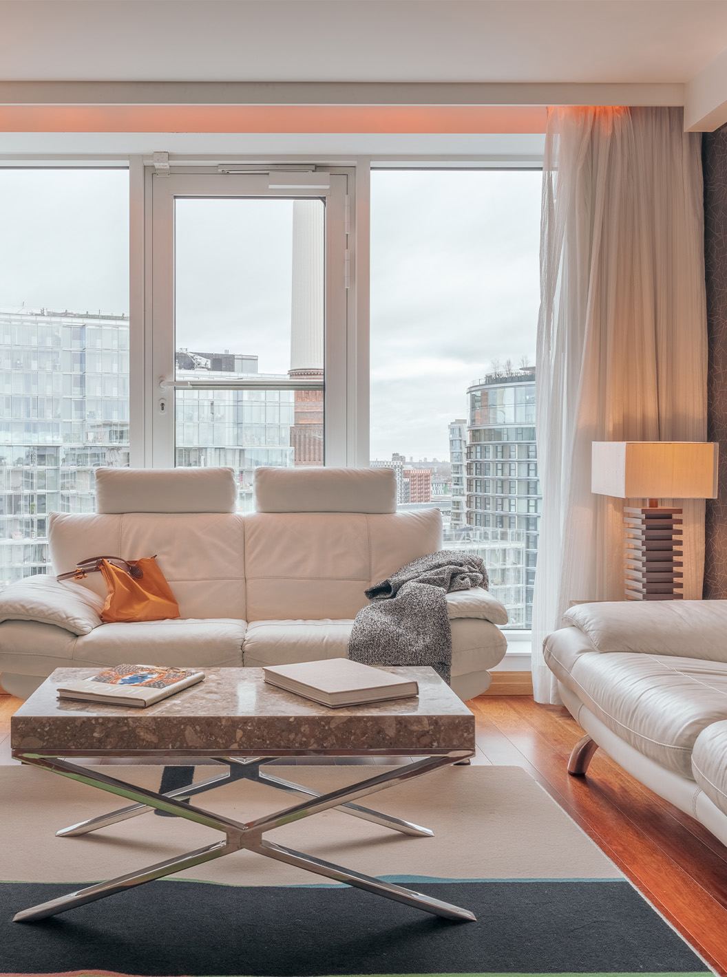 La Suite Signature con 2 habitaciones del Pestana Chelsea Bridge tiene sala de estar con sofá, mesa, televisión y ventanas