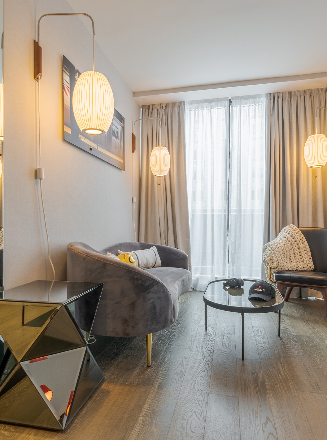 La Suite Junior con Balcón y Vista del Pestana CR7 Times Square tiene una sala de estar con sofá, ventanas grandes y silla