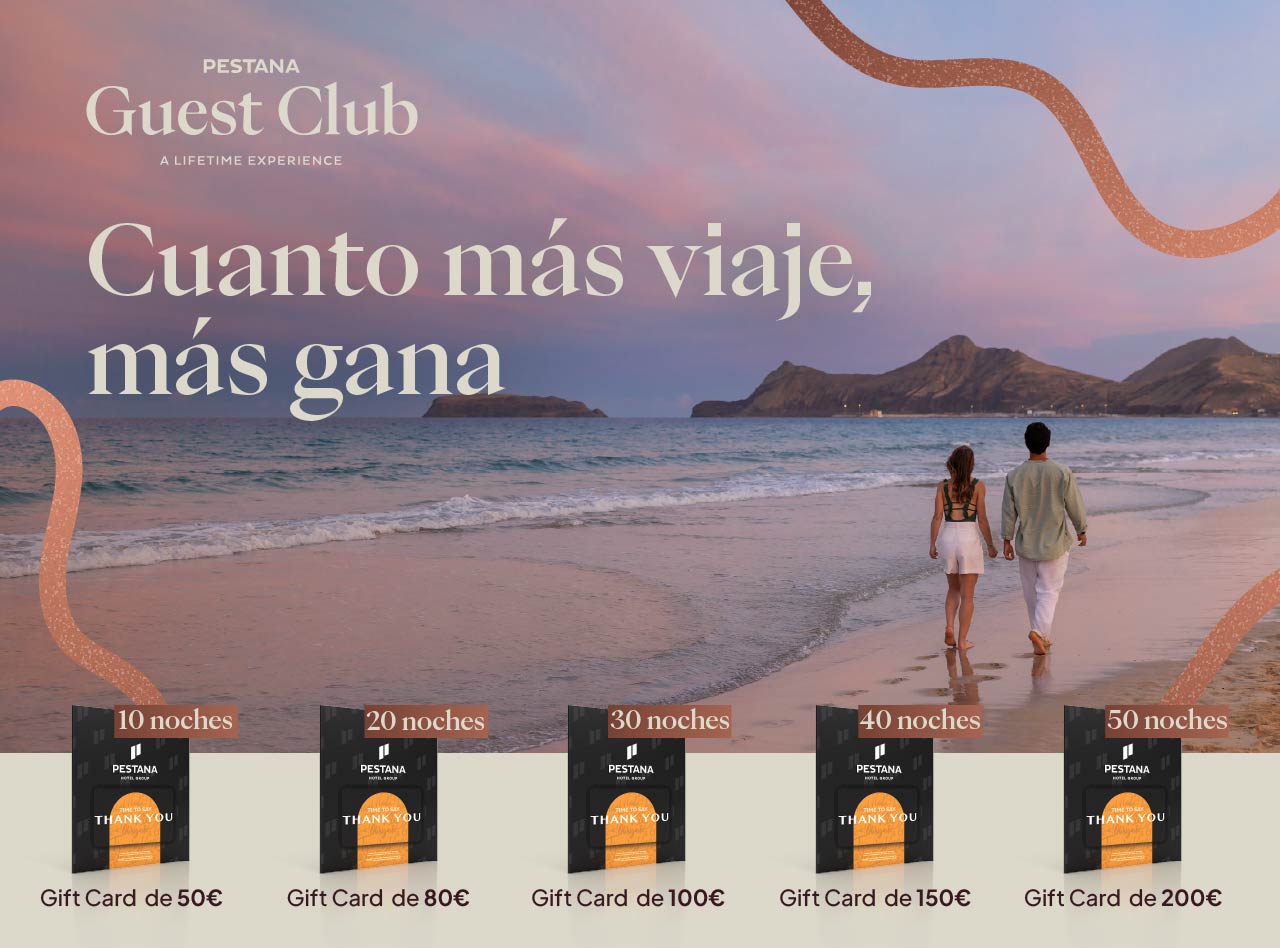 Pareja caminando por la playa al atardecer junto al mar con promoción Pestana Guest Club y tarjetas regalo