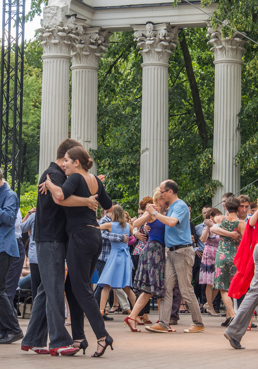 Festival de tango à Buenos Aires avec des couples dansant en plein air devant des colonnes dans un parc