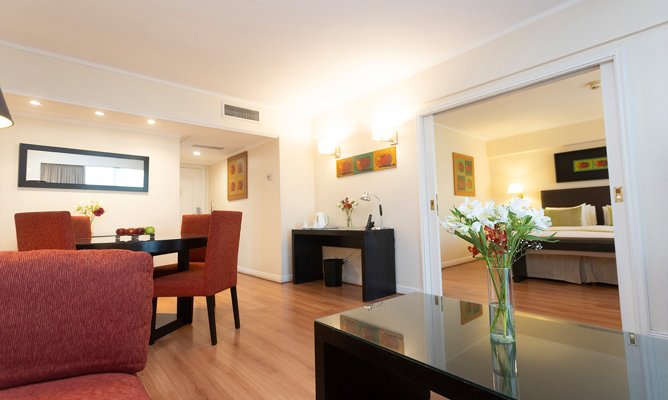 La Chambre Queen Suite du Pestana Buenos Aires a une Table avec Chaises, Miroir, Téléphone et Table Basse