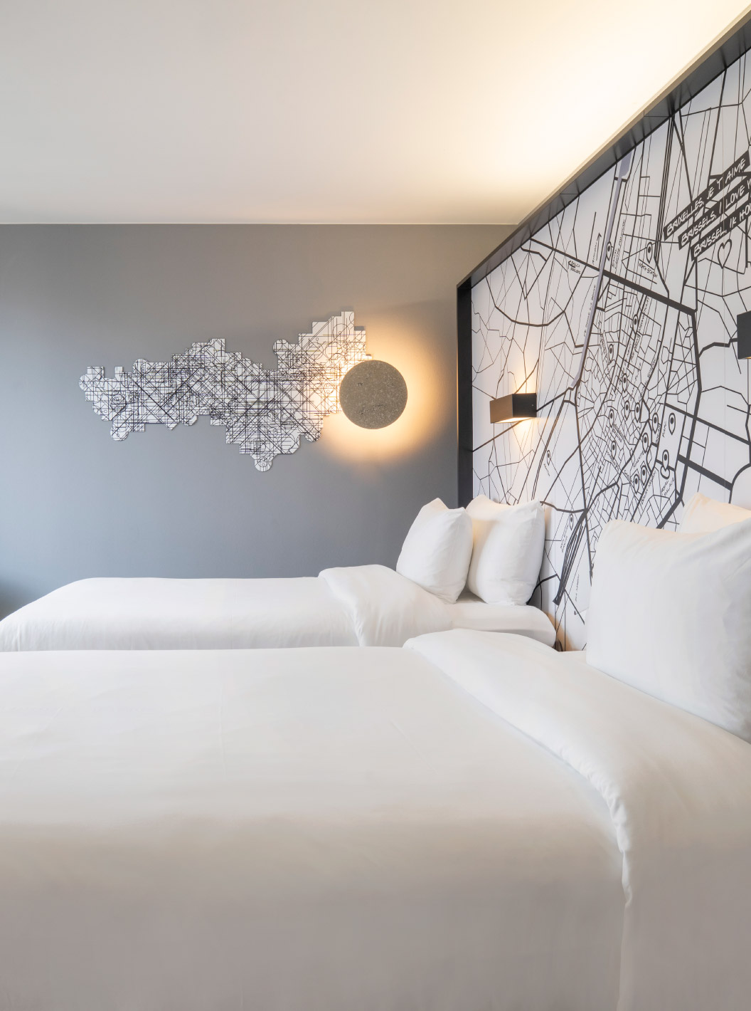 Le Standard Twin du Pestana Brussels Schuman dispose de deux lits simples, d'une chaise jaune et d'une fenêtre avec vue