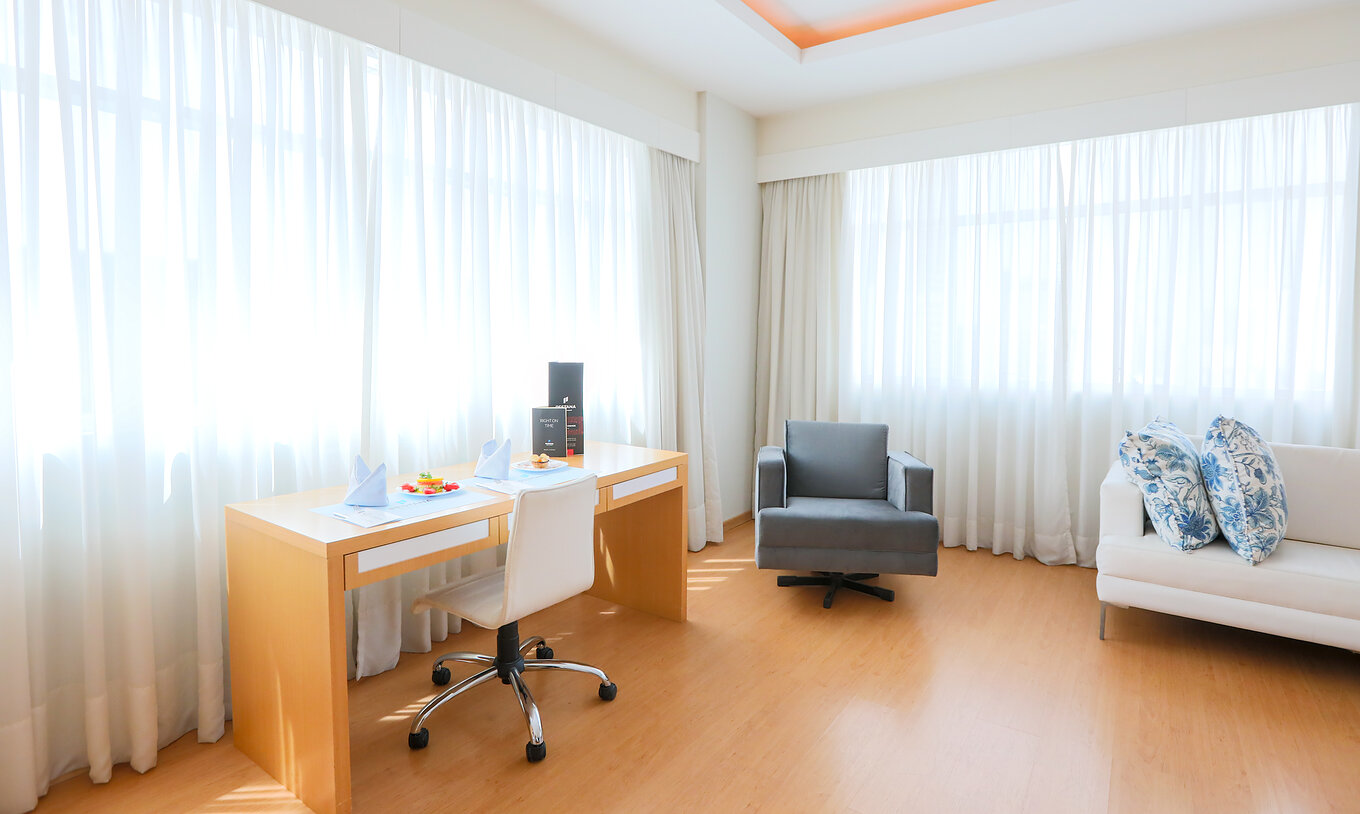 Le Queen Luxe Corner du Pestana Curitiba a des canapés et un bureau près de fenêtres laissant entrer beaucoup de lumière