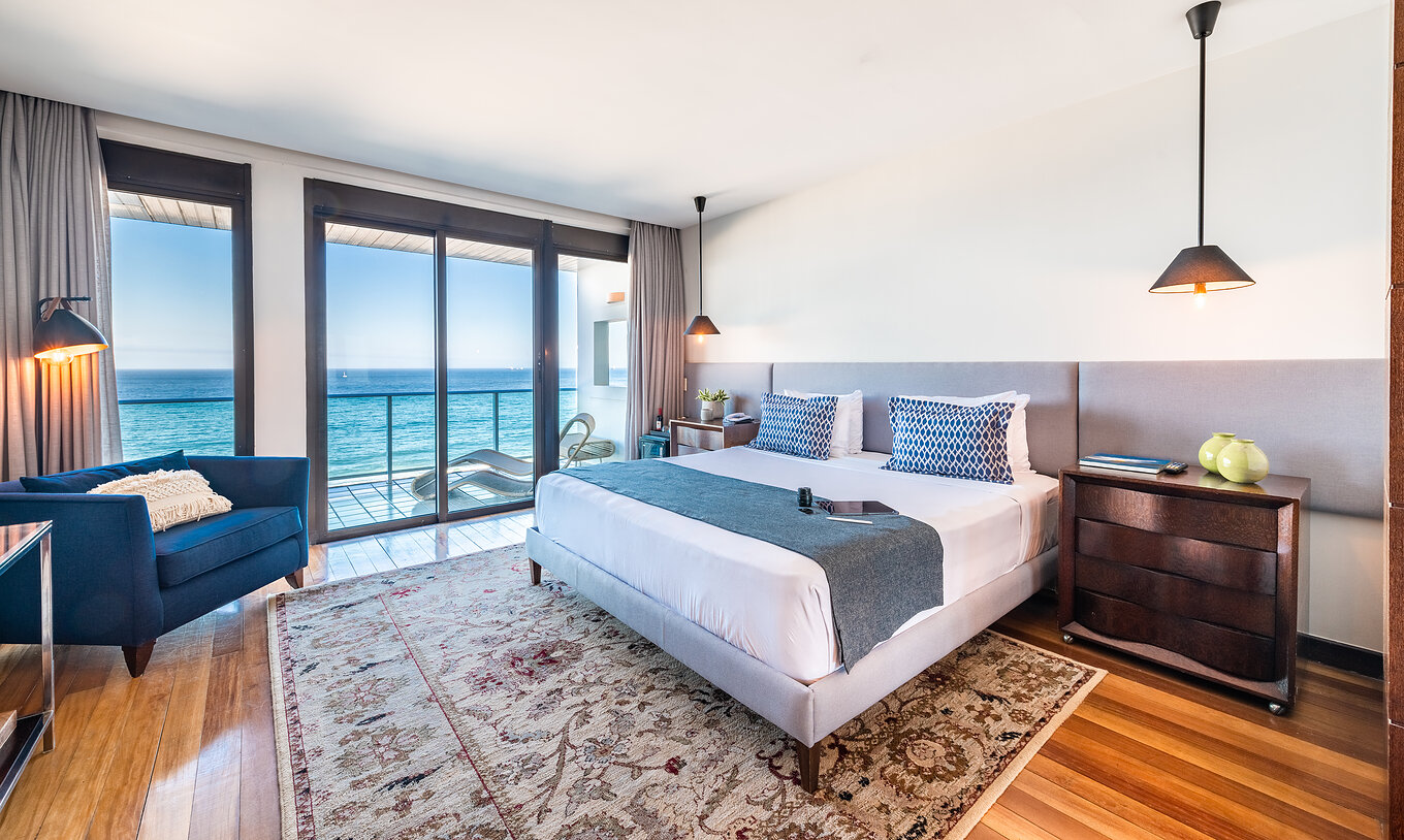 La Suite Présidentielle du Pestana Rio Atlântica a une décoration moderne, un lit double, fauteuil et balcon avec vue mer