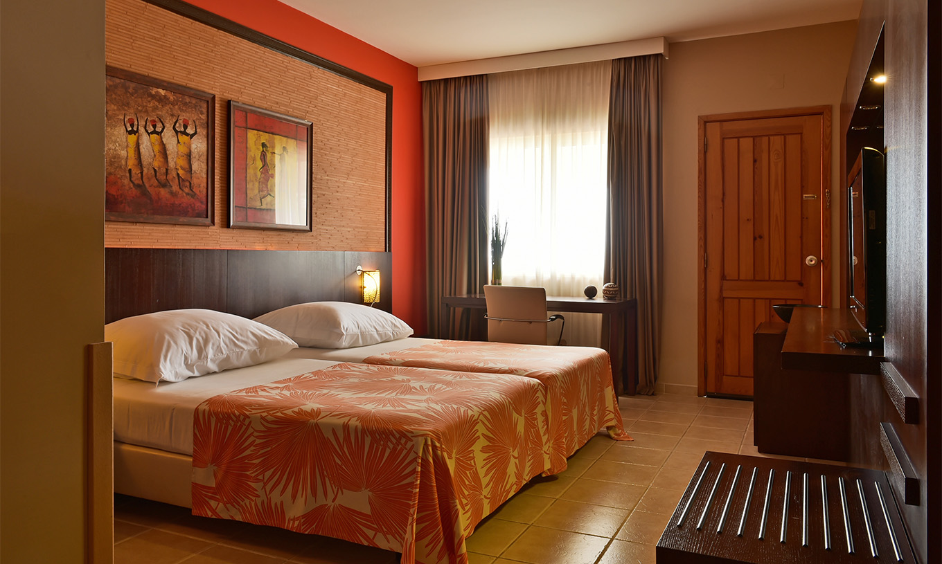 Le Chambre Premium du Pestana Tropico comprend deux lits simples, télévision et bureau avec chaise
