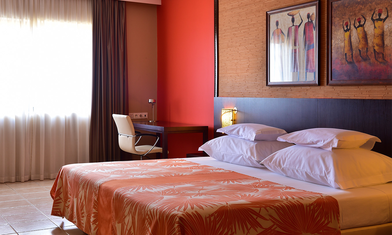 Le Chambre Standard du Pestana Tropico comprend un lit double, bureau avec chaise et table de chevet avec lampe