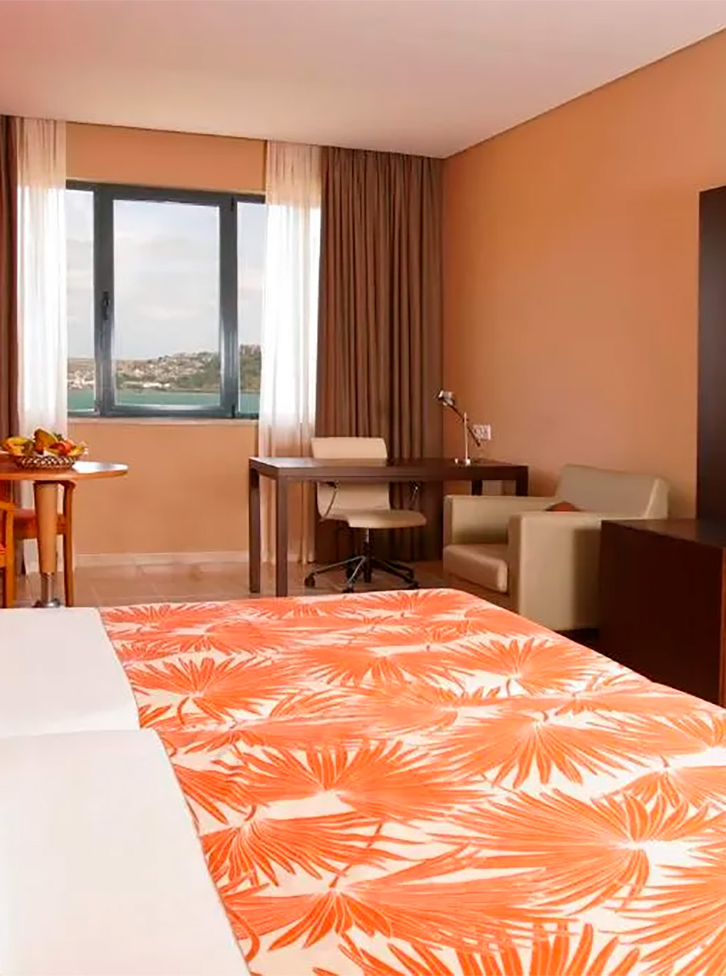 La Suite Premium du Pestana Tropico comprend deux lits simples, bureau avec chaise, une table, et vue sur la mer