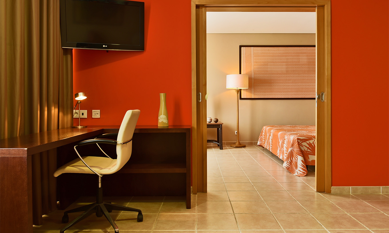 La Suite Premium du Pestana Tropico comprend une télévision et un bureau avec chaise
