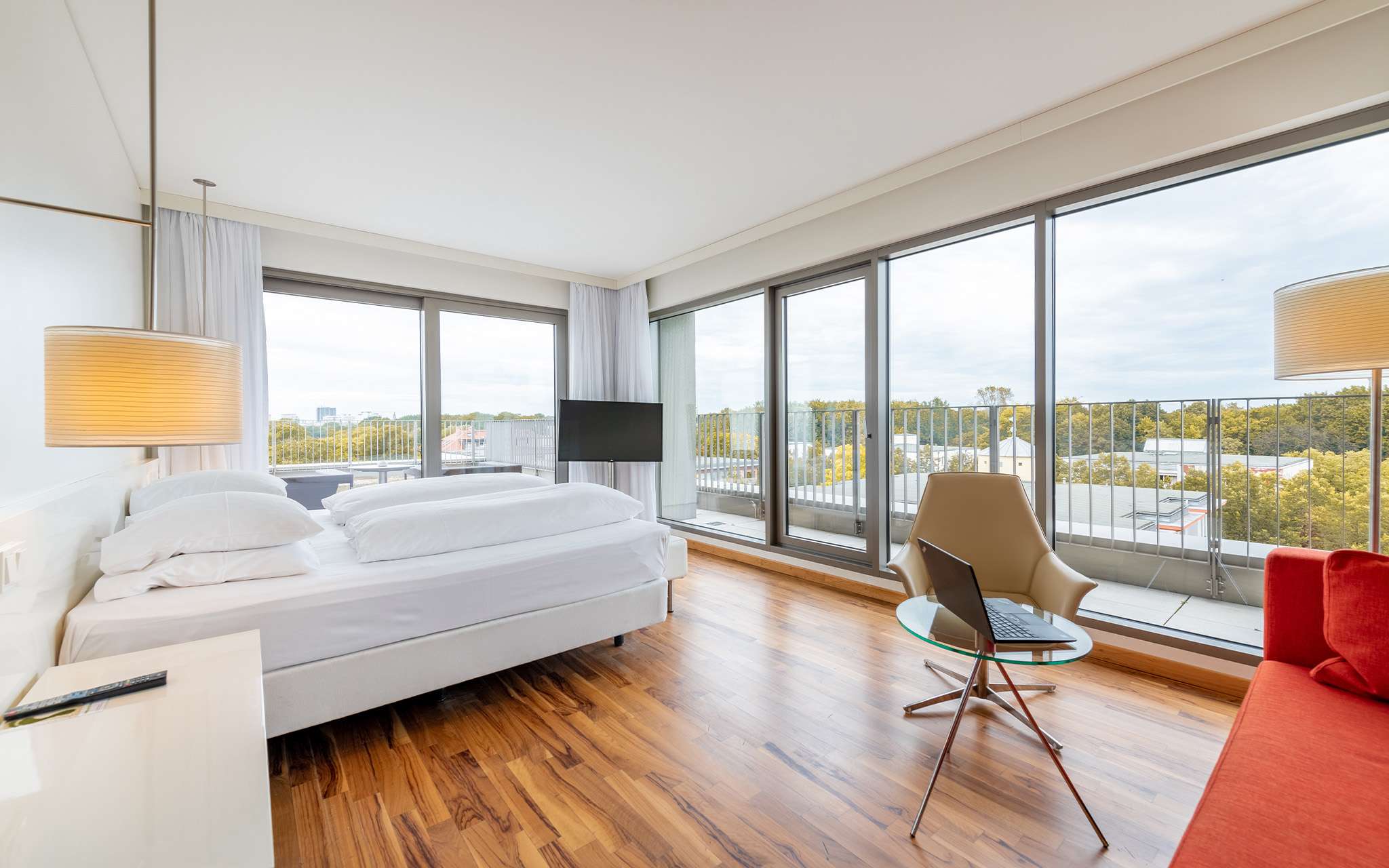 Vue panoramique de la chambre du Pestana Berlin, avec des fenêtres tout autour offrant une vue sur la ville