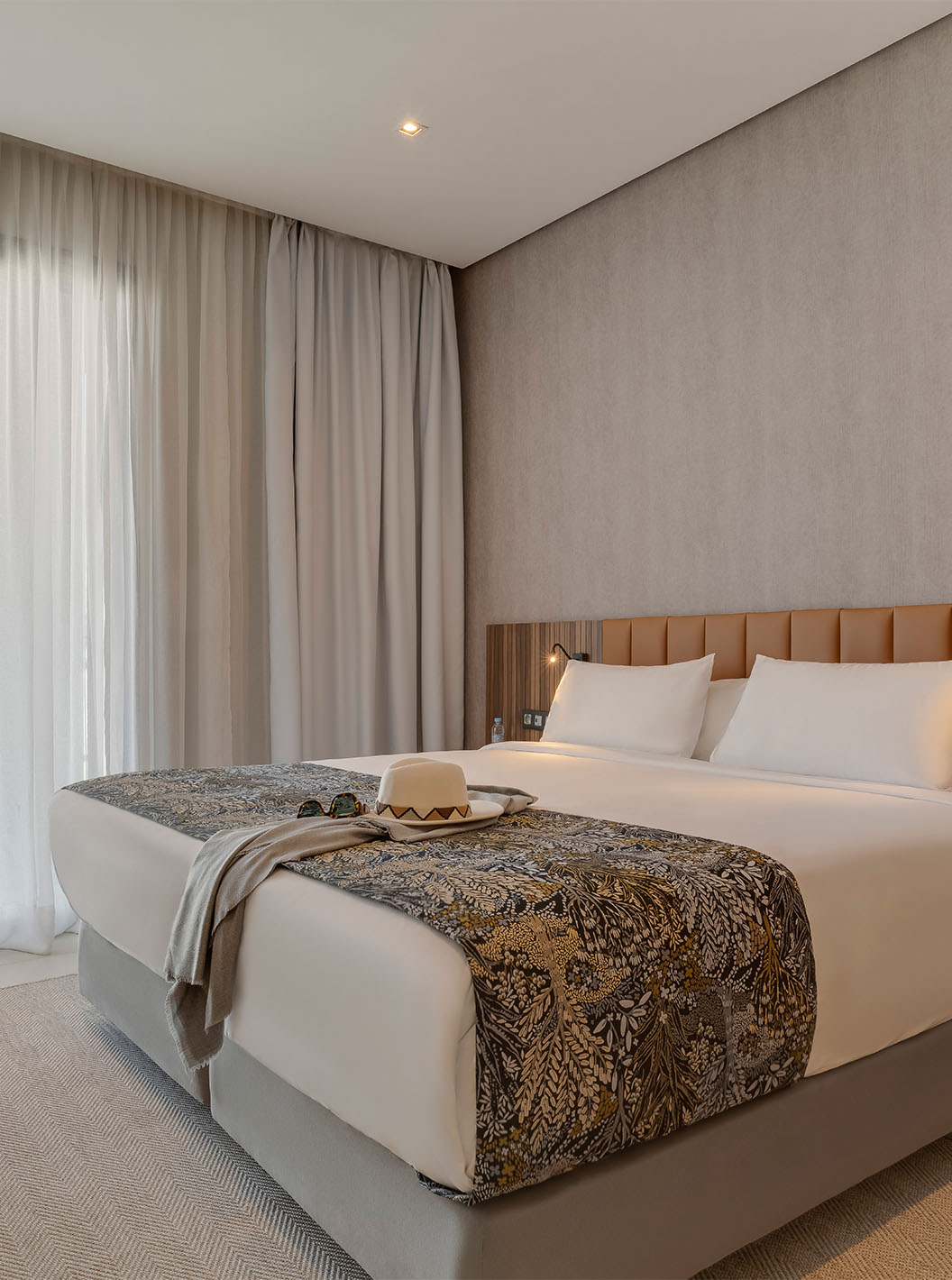 La Suite Familiale Corniche du Pestana Casablanca a une chambre avec un lit double avec une décoration moderne
