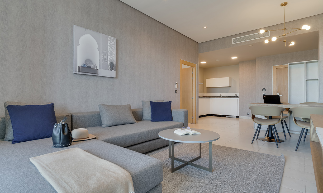 Suite Premium vue latérale sur l'océan au Pestana Casablanca avec salon moderne et cuisine ouverte lumineuse