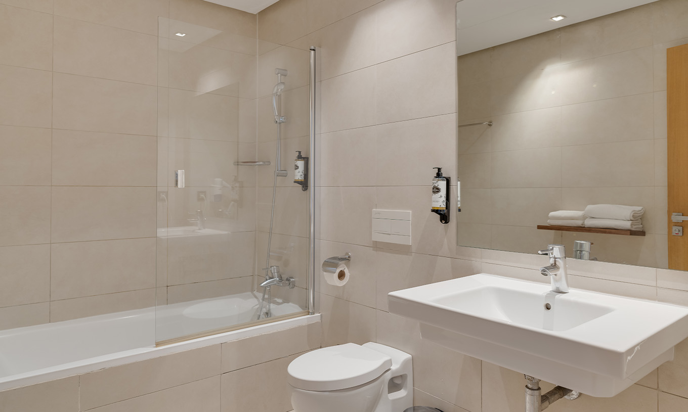La Suite du Pestana Casablanca a une salle de bain dans des tons neutres avec baignoire, WC et lavabo