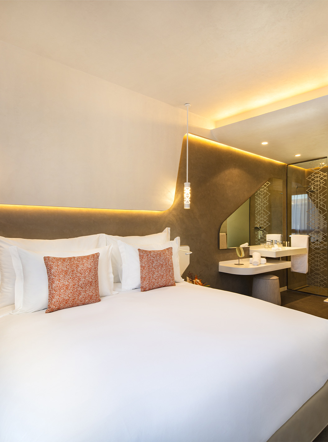 La Junior Suite du Pestana CR7 Marrakech a un grand lit double, des lumières au mur et salle de bain dans la chambre
