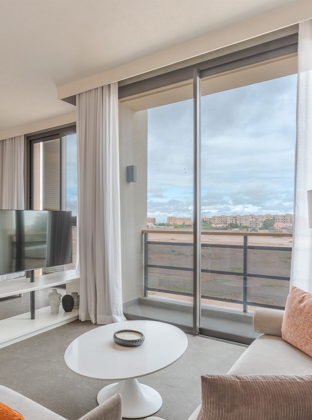 La Junior Suite du Pestana CR7 Marrakech a un balcon et un coin salon dans la chambre, avec canapés et télévision