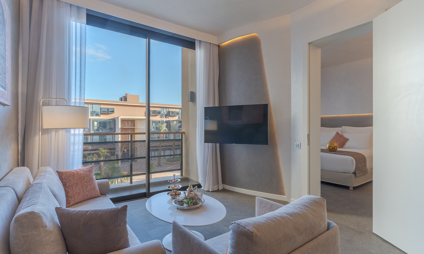 La suite Avenue du Pestana CR7 Marrakech a un salon avec canapés et télévision, et un balcon avec vue