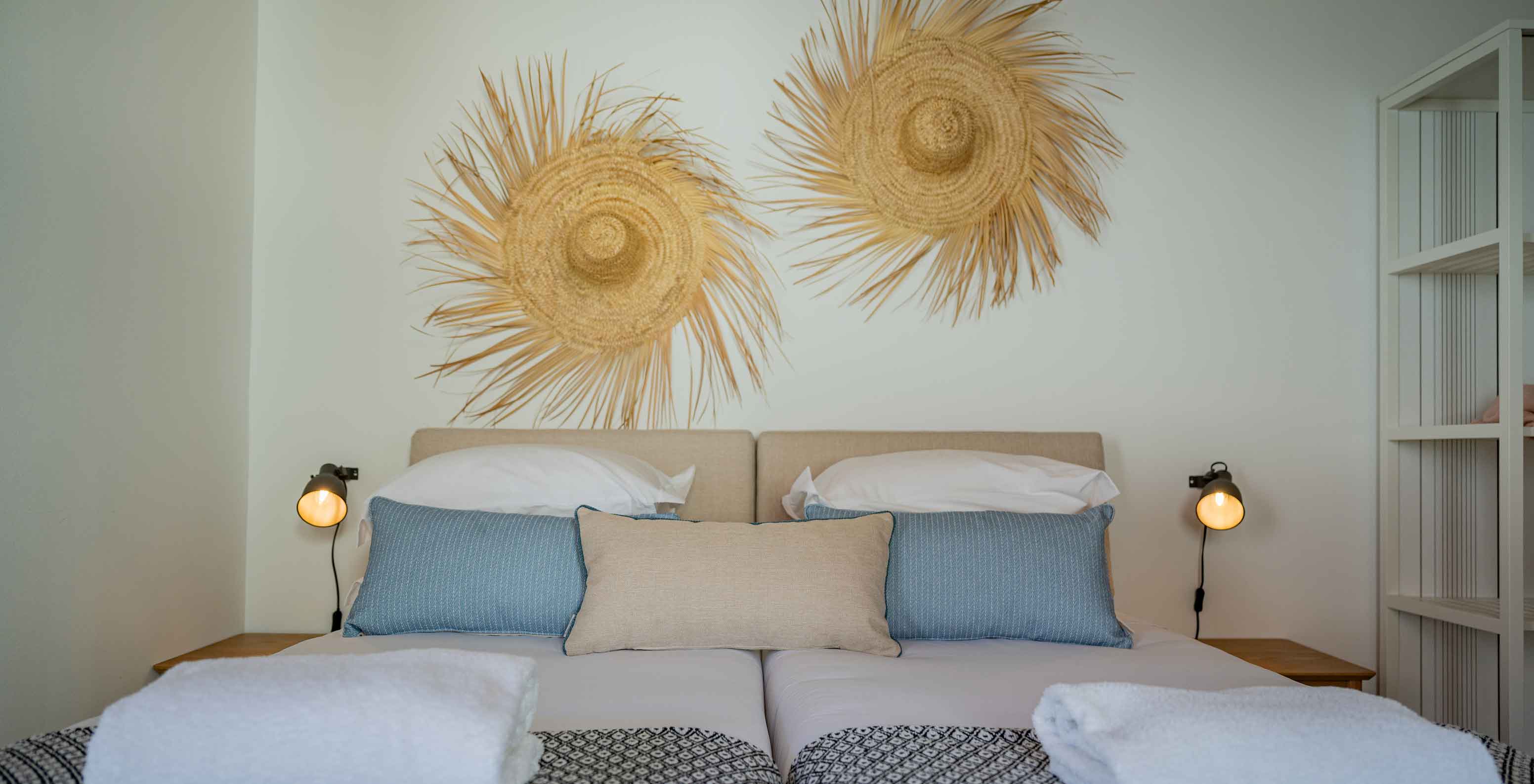 La Standard Villa T2 du Pestana Comporta Village Residences dispose d'un lit double avec décoration en paille sur le mur