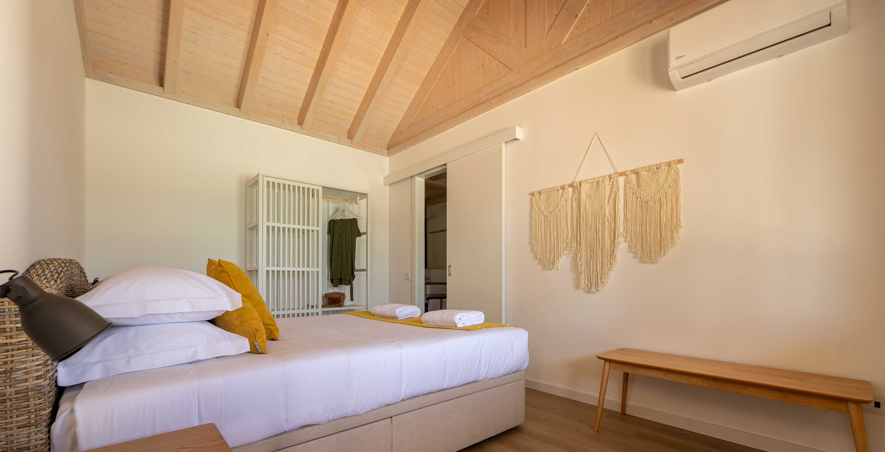 La Standard Villa du Pestana Comporta Village Residences dispose d'une chambre avec lit, table et chaise en osier