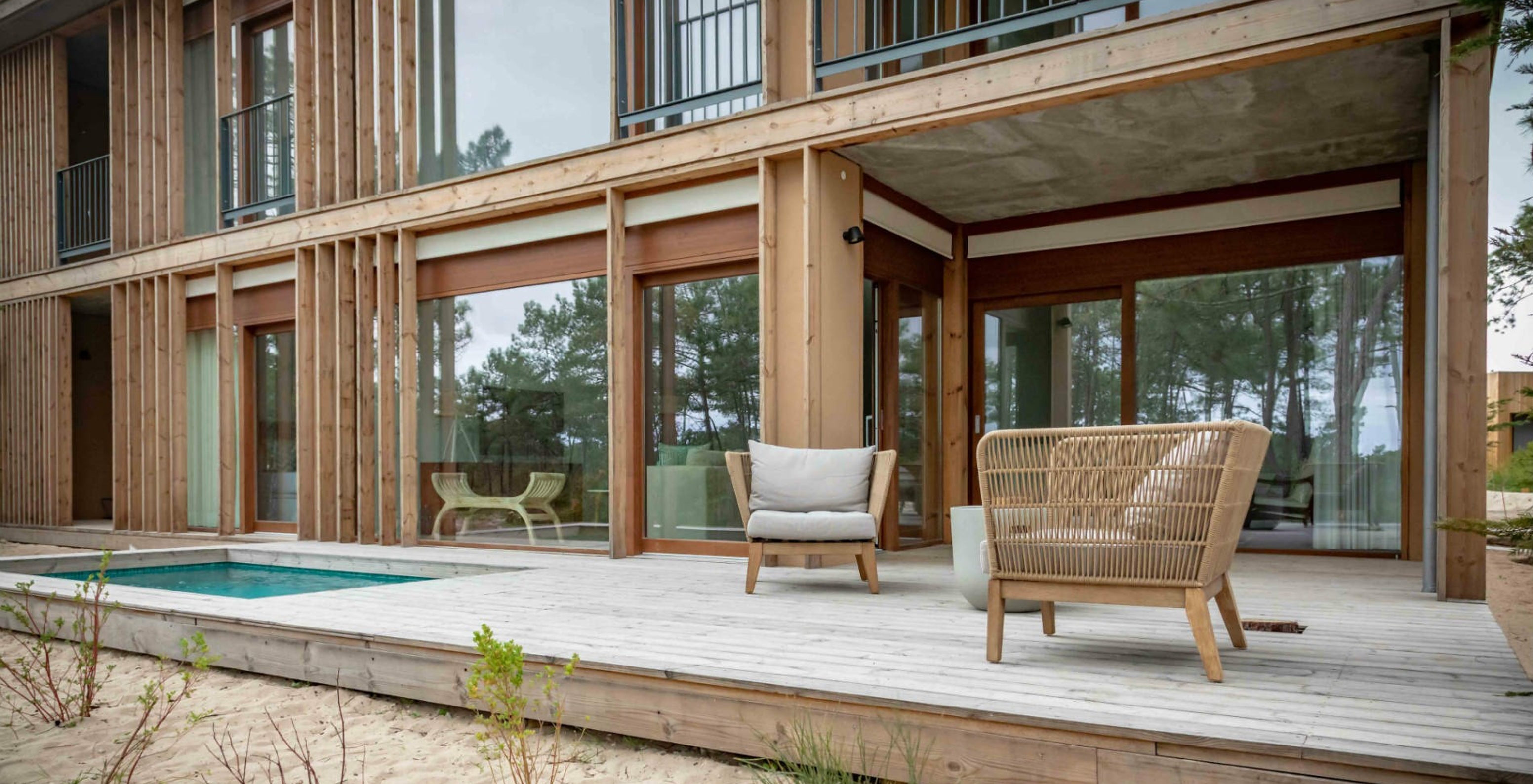 L'appartement Eco Village rez-de-chaussée Vues du Pestana Tróia Eco Resort a une terrasse avec piscine et deux chaises