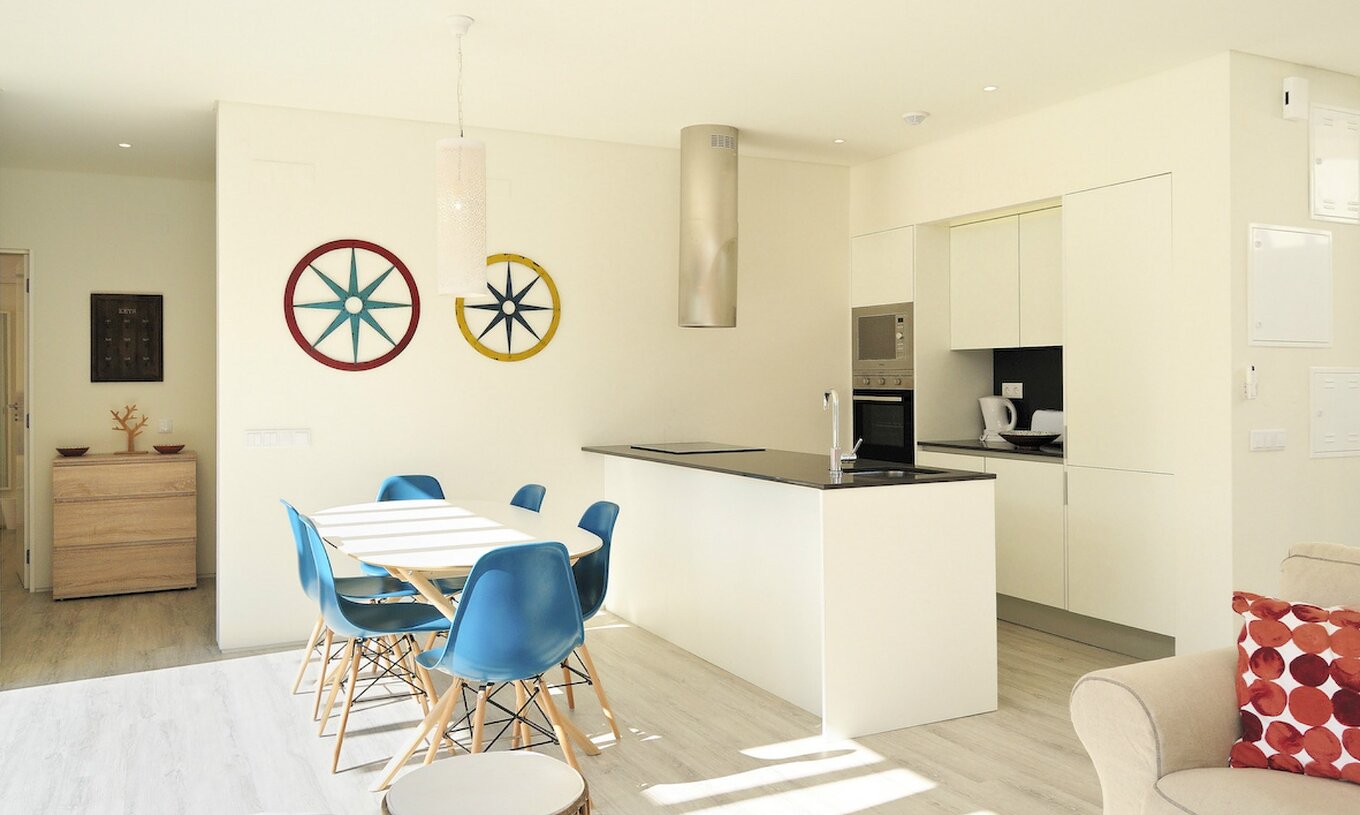 Les villas de 3 chambres du Pestana Tróia Eco Resort ont une cuisine avec plan de travail et une table avec chaises