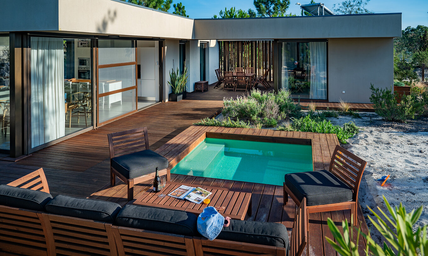 Les Beach Villas avec piscine pour enfants du Pestana Tróia Eco Resort ont des canapés et des chaises près de la piscine