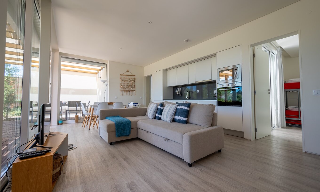 La Green Villa avec piscine privée du Pestana Tróia Eco Resort a une salle combinée à la cuisine avec canapé et table