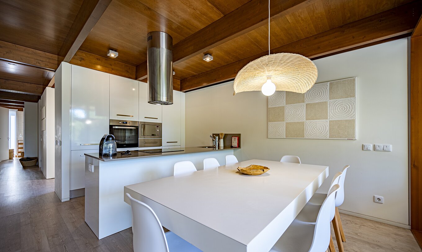 La Tree Villa avec piscine privée du Pestana Tróia Eco Resort a une cuisine équipée et une table et chaises à côté