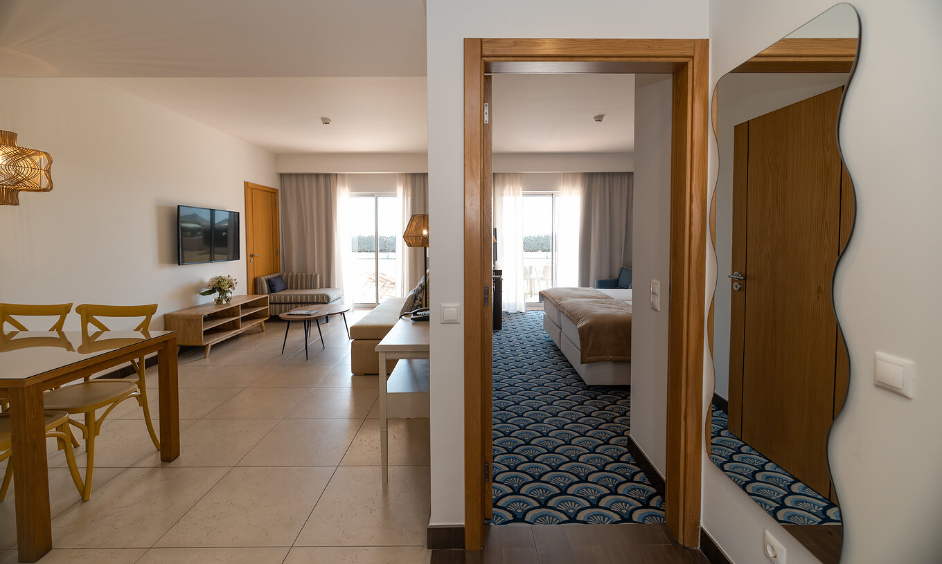 Appartement T1 Vue Jardin au Pestana Alvor Beach Villas dispose d'un salon avec canapé, TV et fenêtre avec balcon