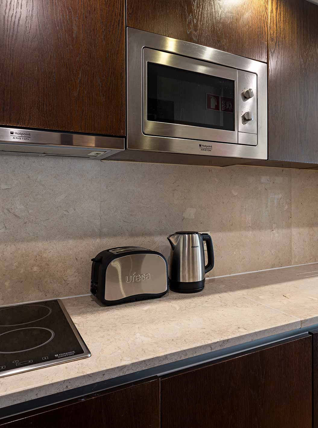 La Cliff Studio du Pestana Alvor Praia a une cuisine équipée en bois foncé et pierre, avec cuisinière et micro-ondes