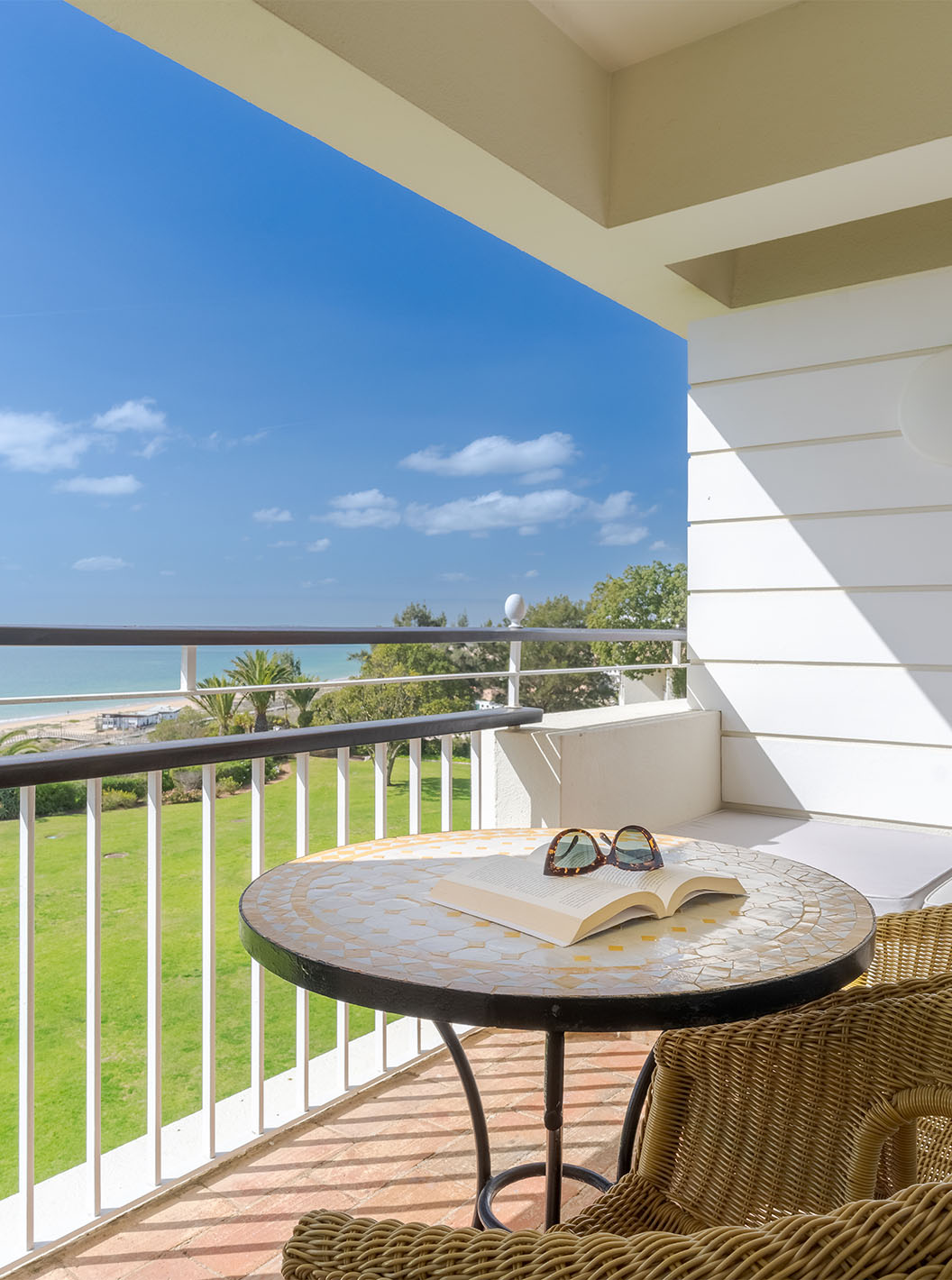 Le Deluxe Vue Mer du Pestana Alvor Praia a balcon avec chaises, table et canapé avec vue sur la mer, plage et jardin