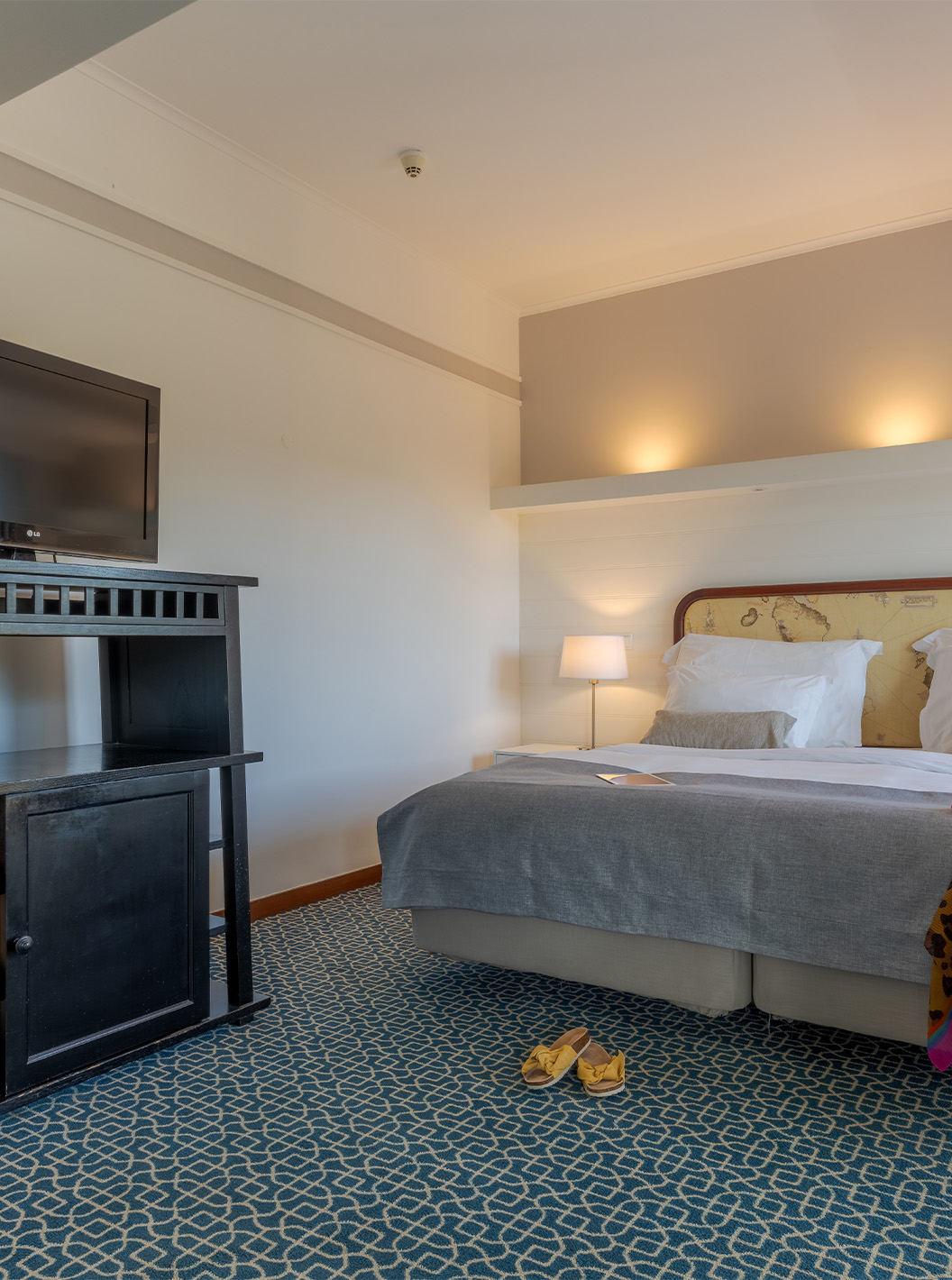 Le Supérieur du Pestana Alvor Praia a deux lits unis avec tête de lit, meuble noir avec télévision et tapis avec motif