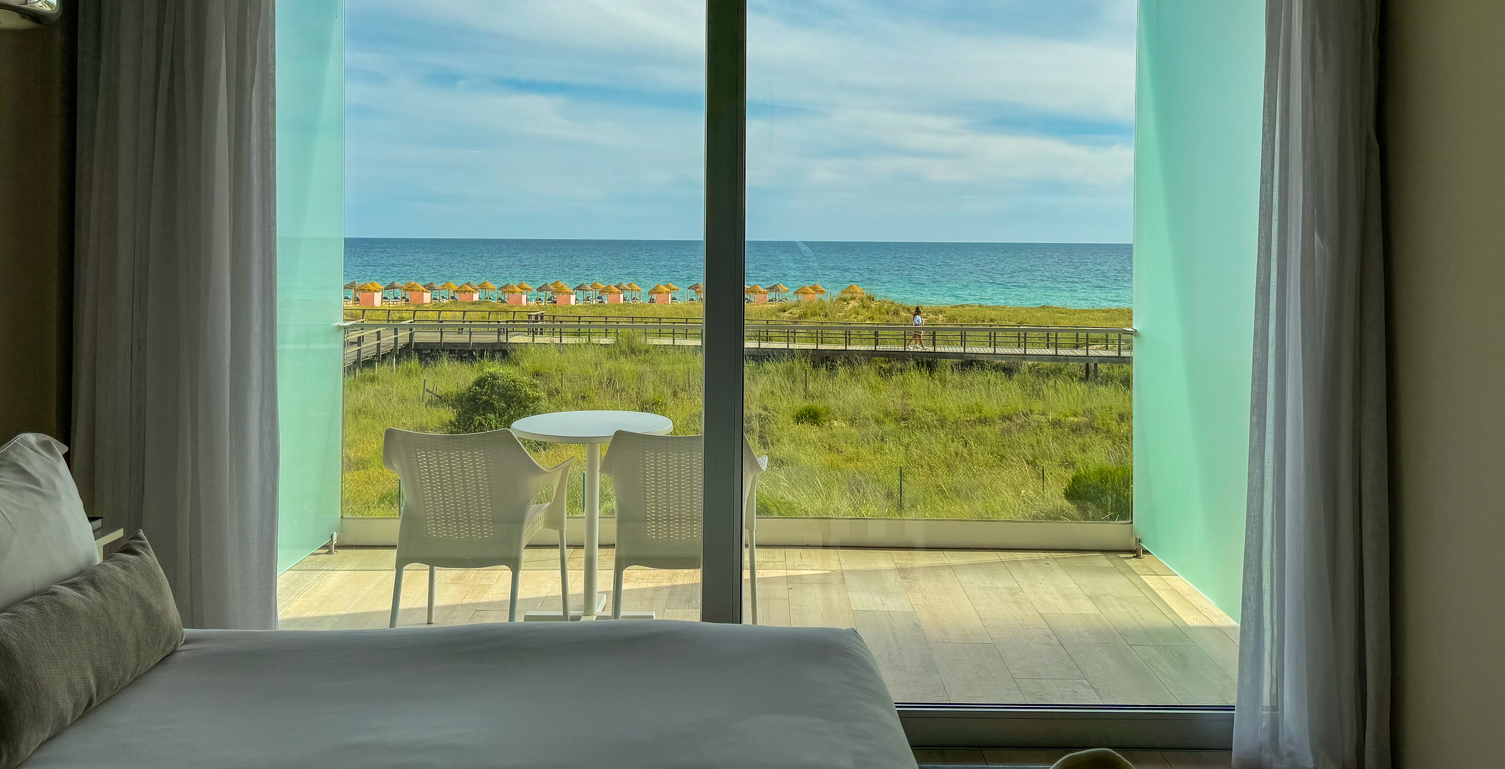 La Suite Double Vue Mer du Pestana Alvor South Beach a un balcon avec table et chaises et vue mer