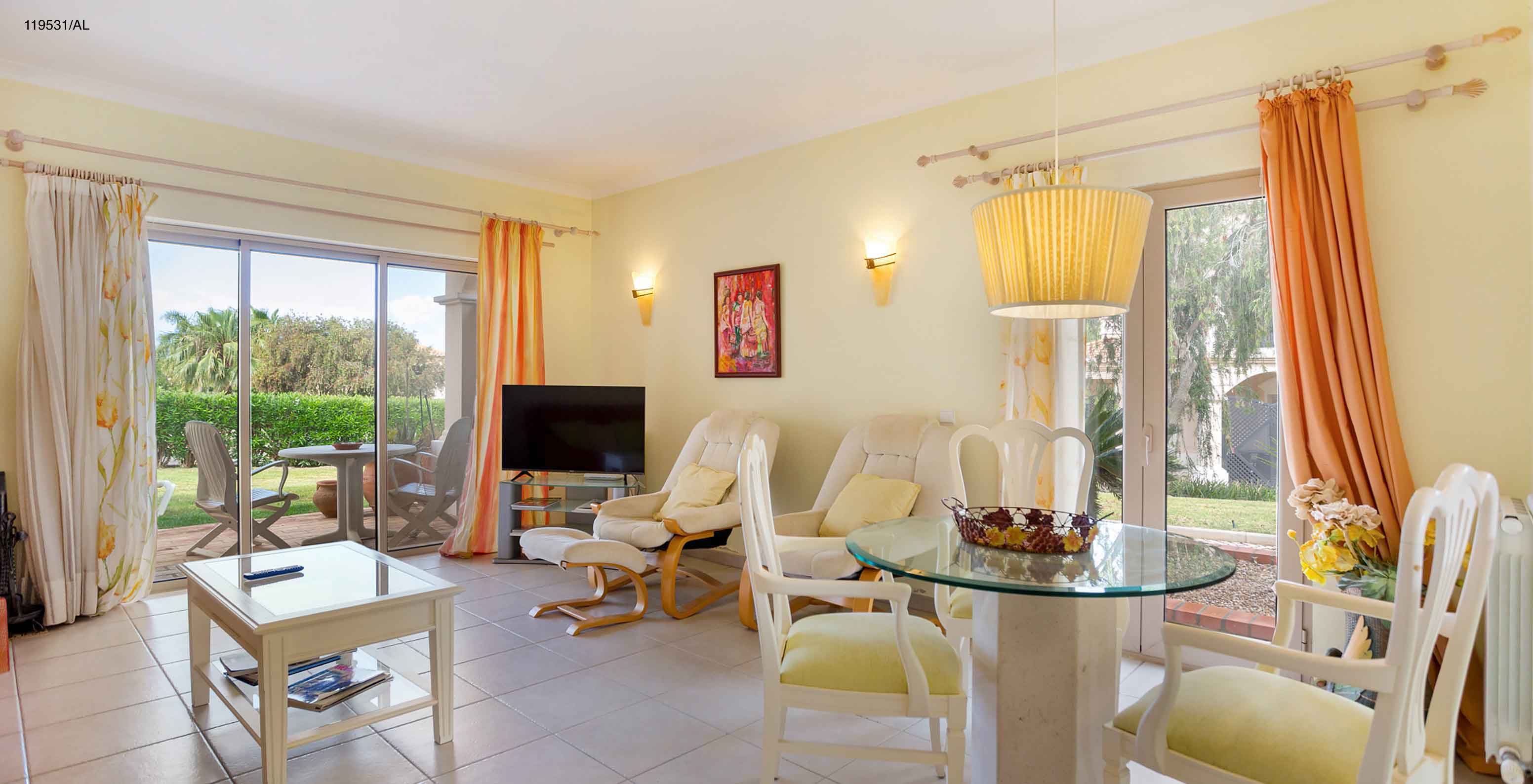 L'appartement Pestana Carvoeiro Golf T1 Standard dispose d'un salon avec une télévision, tables, chaises et vue extérieure