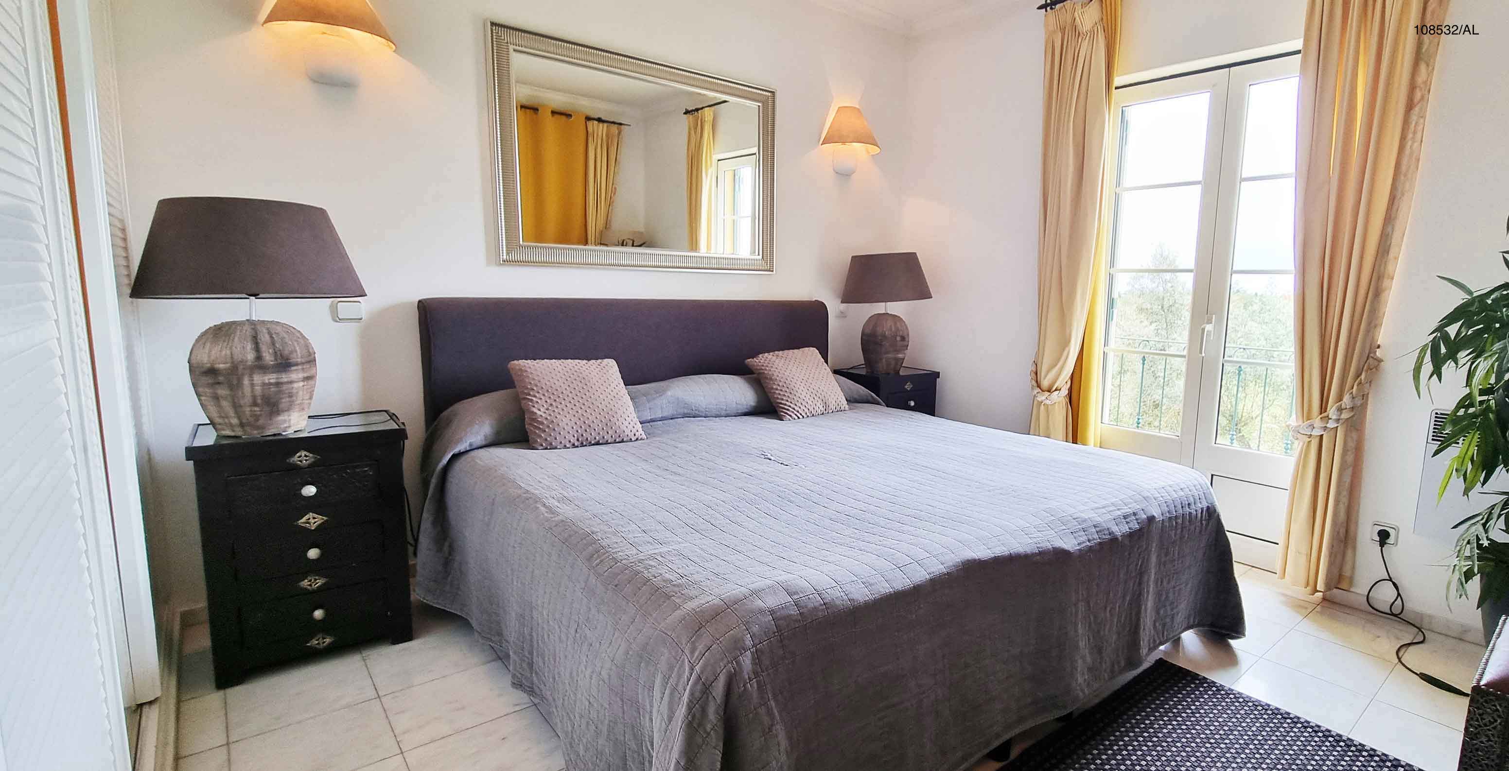 L'appartement Pestana Carvoeiro Golf T1 Superior dispose d'un lit double avec deux tables de chevet et un miroir