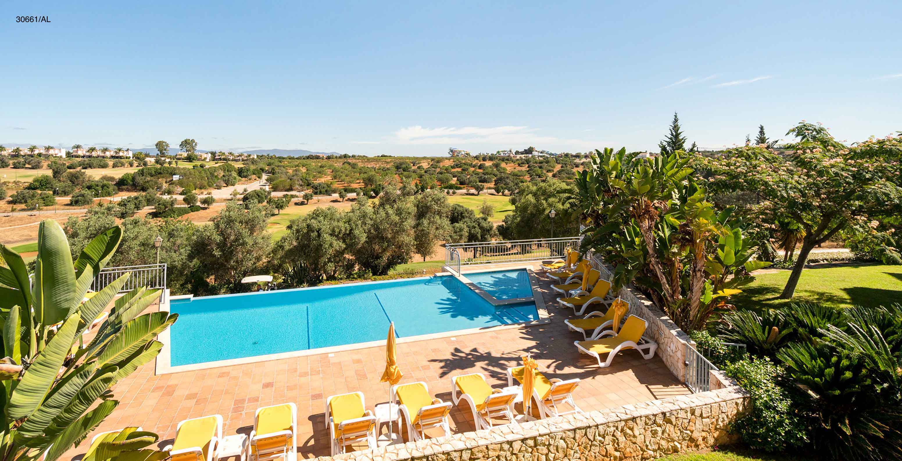 L'appartement Pestana Carvoeiro Golf T1 Superior dispose d'une piscine extérieure avec des chaises longues jaunes