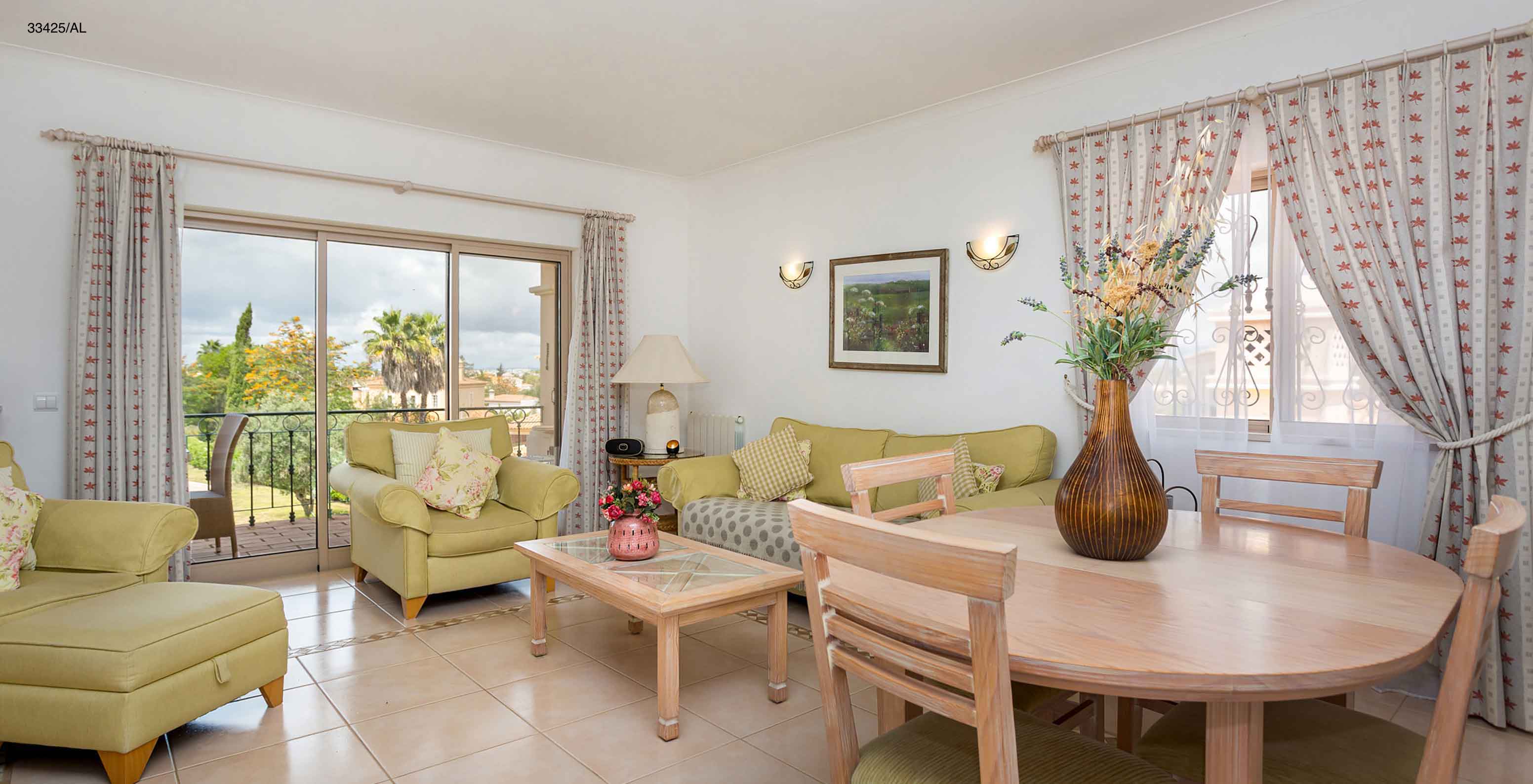L'appartement Pestana Carvoeiro Golf T2 Standard dispose d'un salon avec des canapés verts et une table ronde