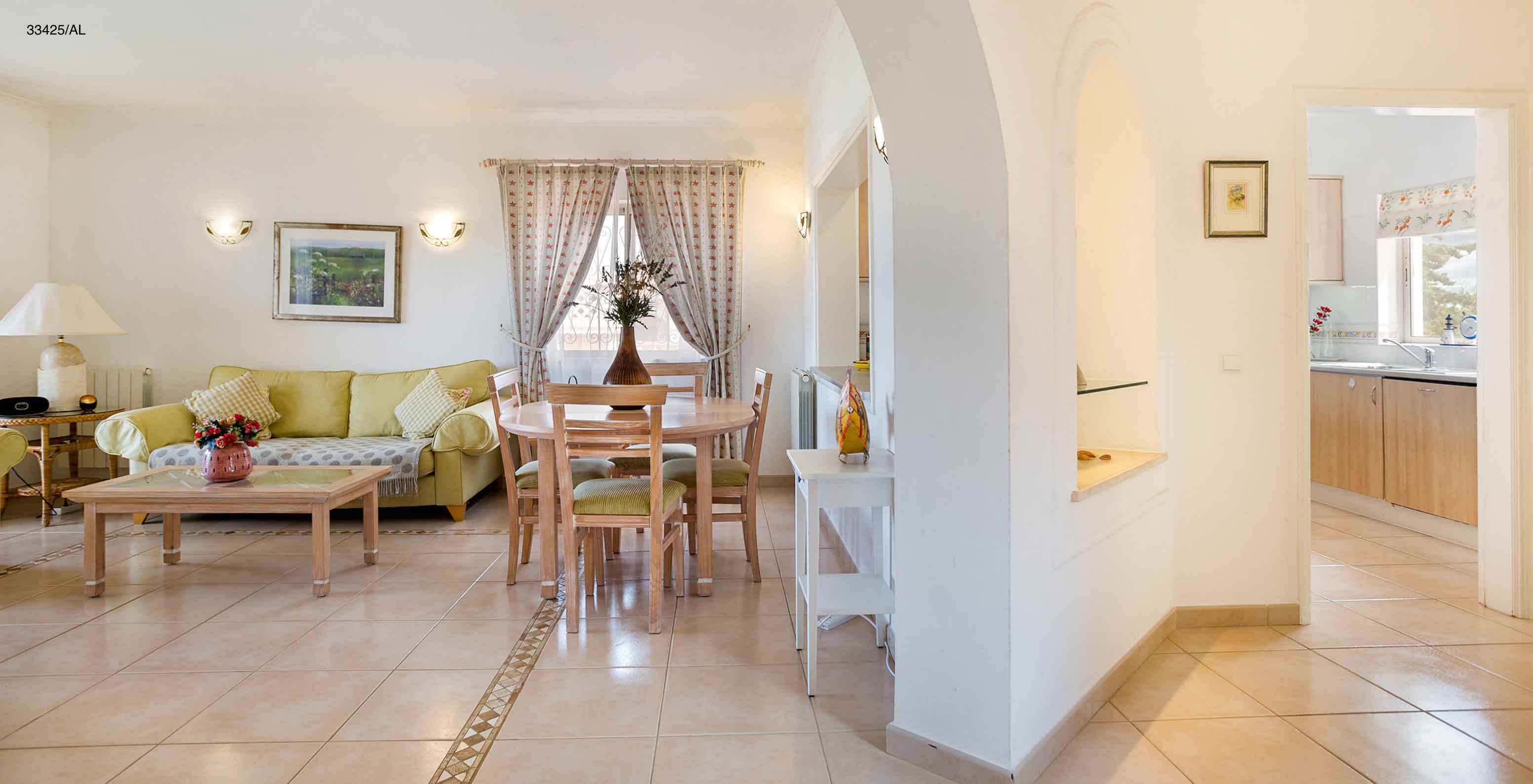 L'appartement Pestana Carvoeiro Golf T2 Standard dispose d'un salon avec des canapés verts et une table avec des chaises