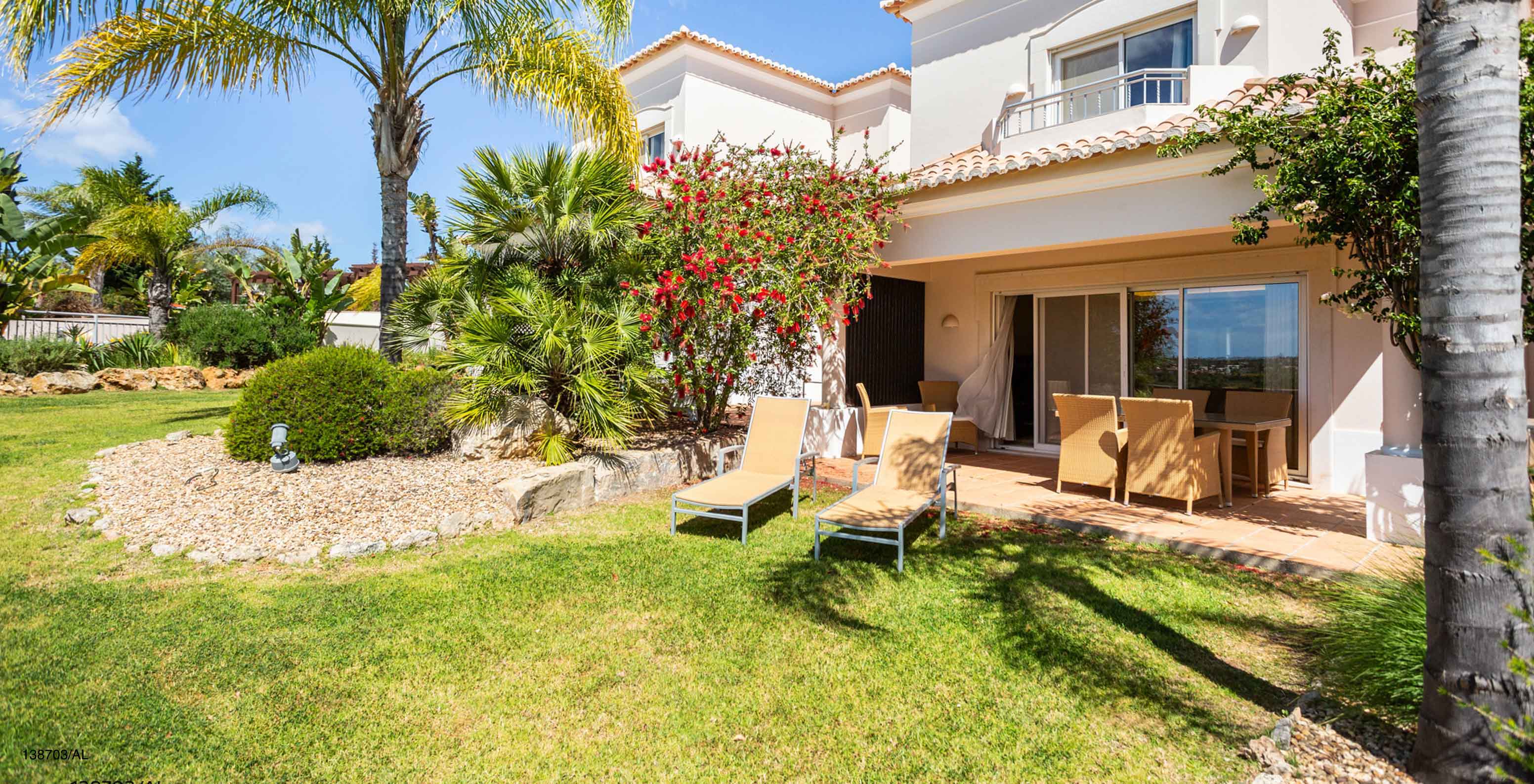 L'appartement Pestana Carvoeiro Golf T2 Superior dispose d'un espace extérieur avec une pelouse et des chaises longues jaunes