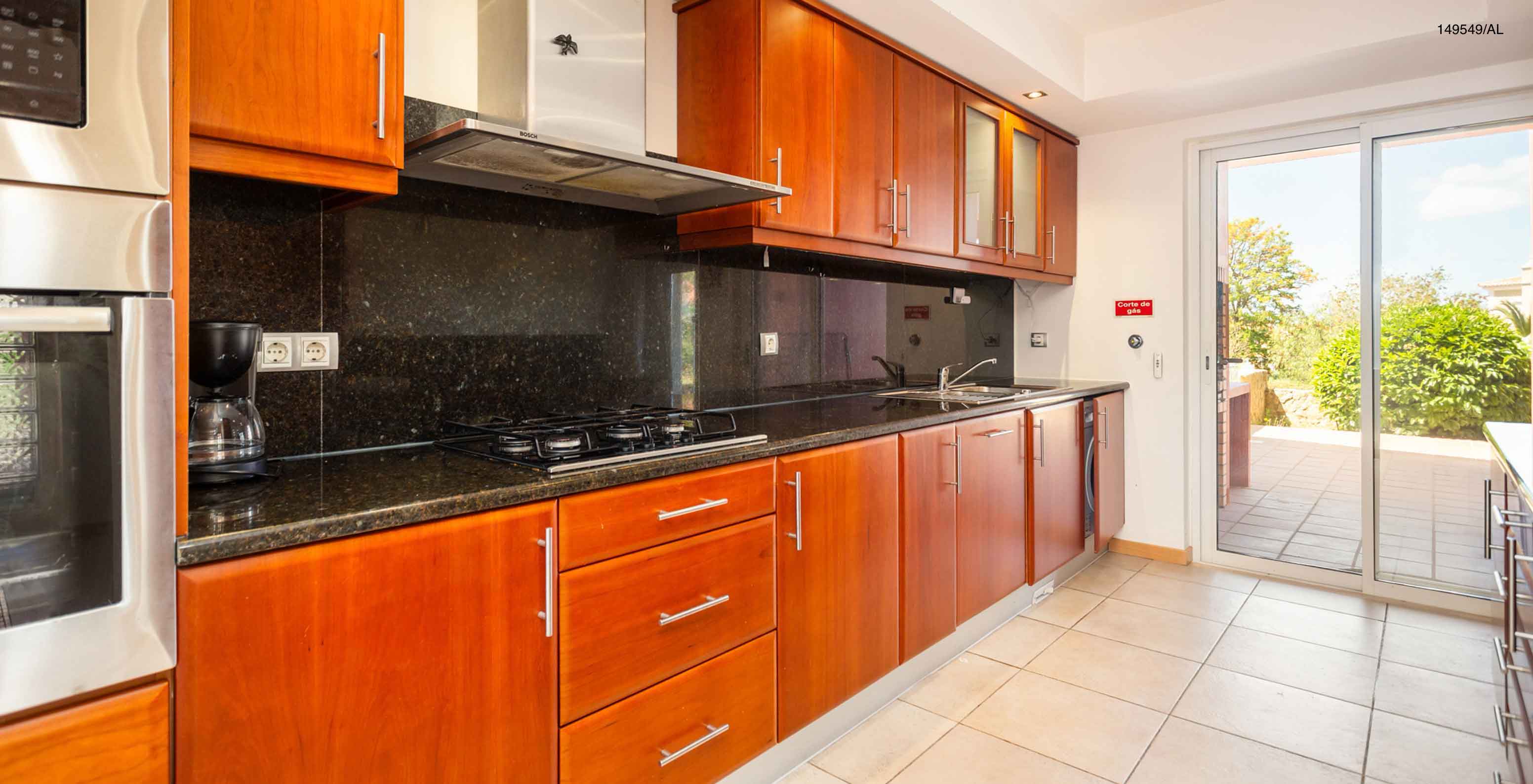 L'appartement Pestana Carvoeiro Golf T2 Superior dispose d'une cuisine avec des armoires en bois et des appareils
