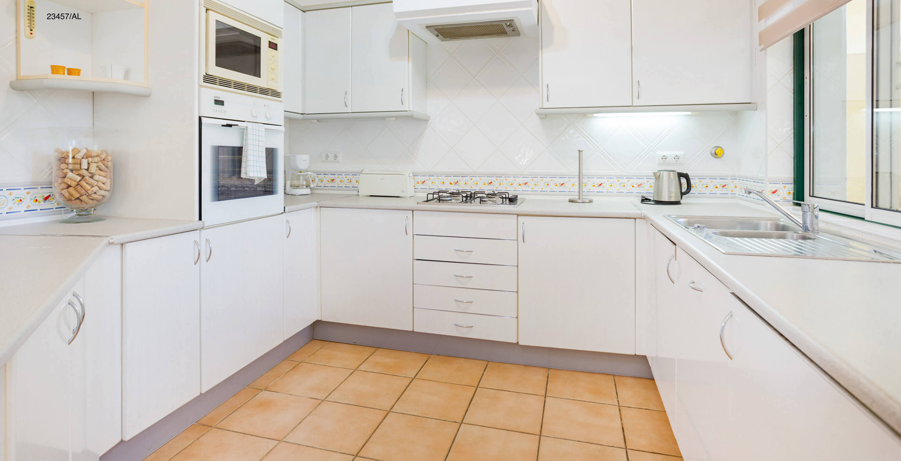 L'appartement Pestana Carvoeiro Golf T3 Standard dispose d'une cuisine avec des armoires blanches et un plan de travail
