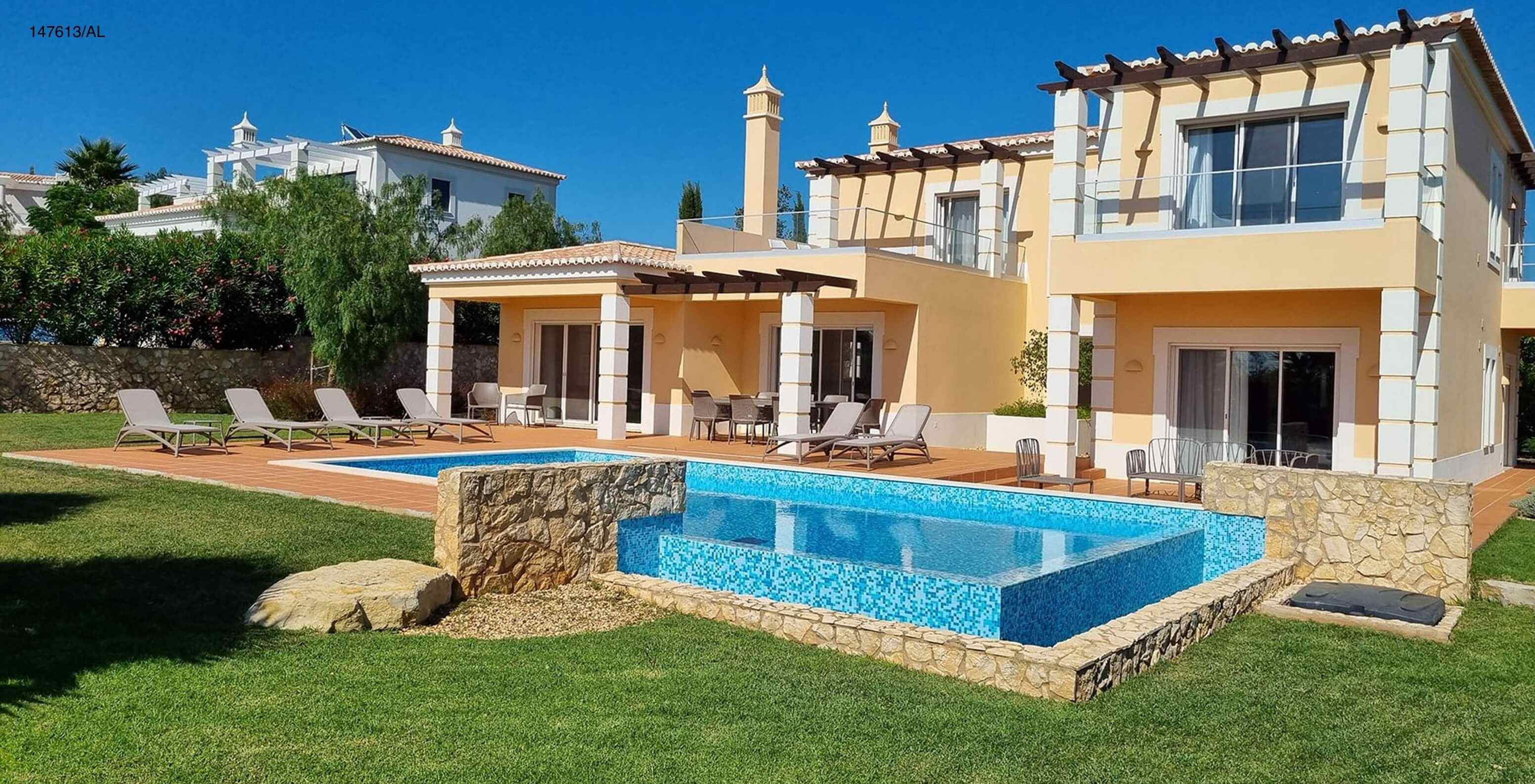 La villa Pestana Carvoeiro Golf V5 Superior dispose d'un espace extérieur avec une piscine une pelouse et des chaises longues