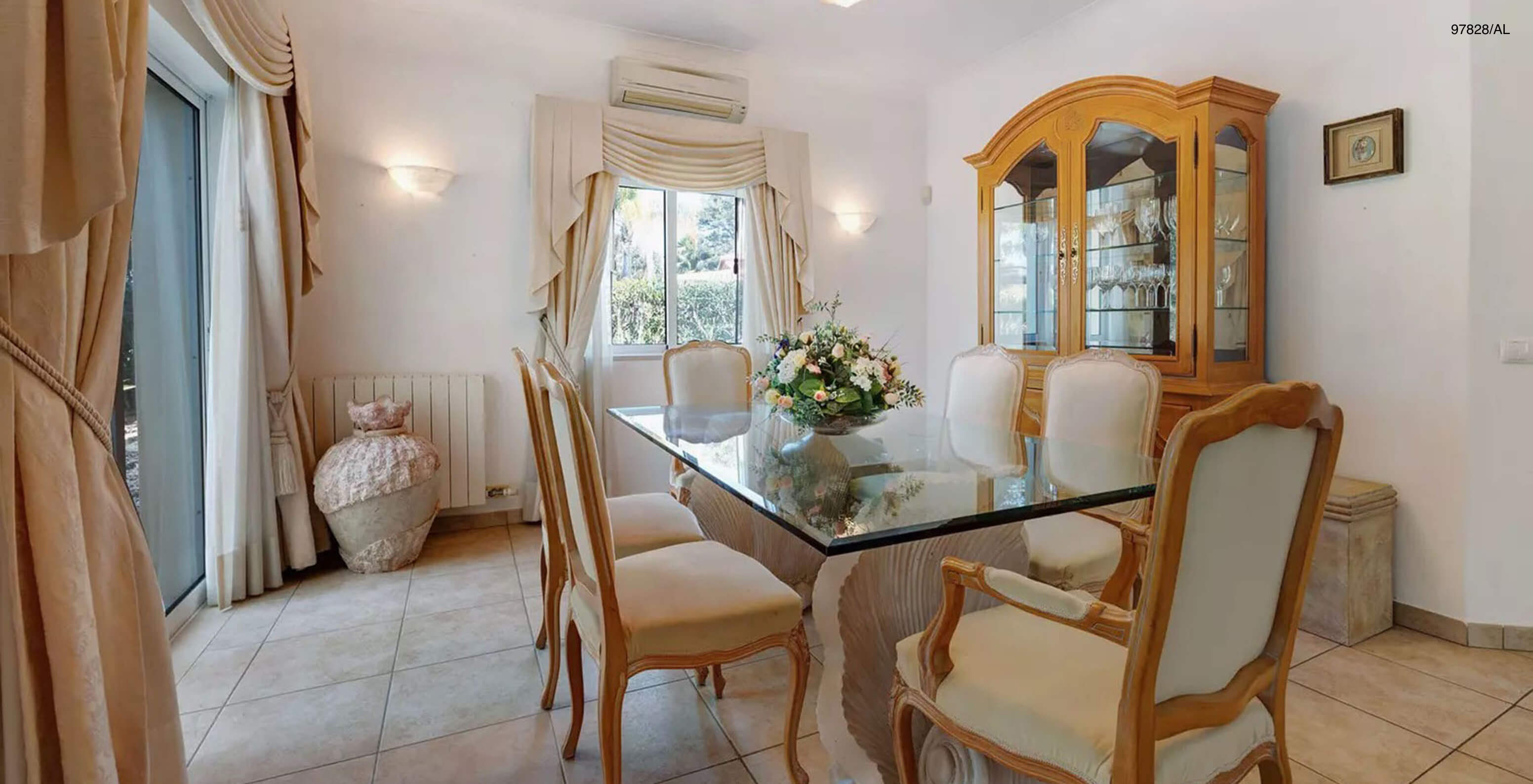 La villa Pestana Carvoeiro Golf V3 Standard dispose d'une salle à manger avec une table en verre, des chaises et un placard