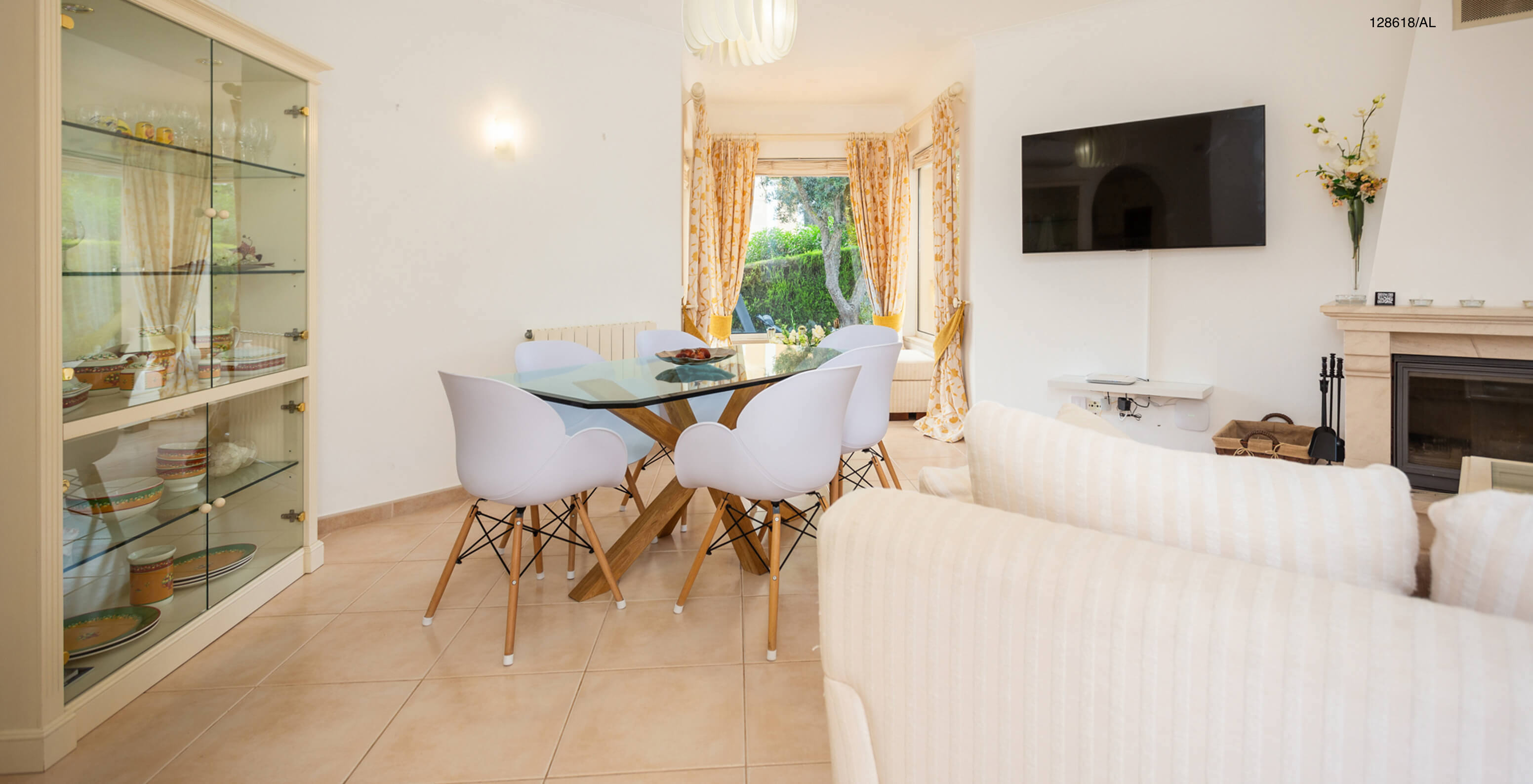 La villa Pestana Carvoeiro Golf V3 Superior dispose d'un salon avec une table en verre, des chaises et une télévision