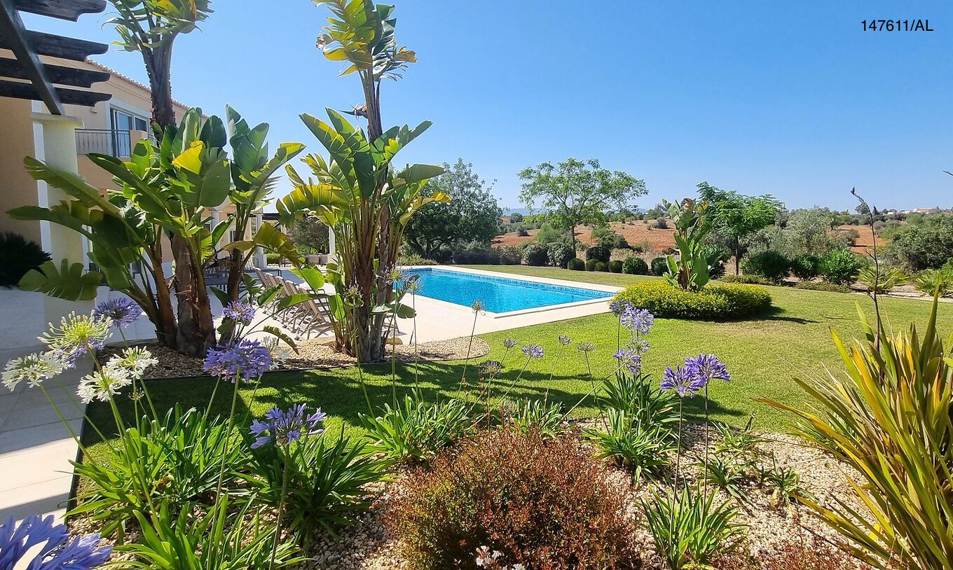 La villa Pestana Carvoeiro Golf V5 Superior dispose d'un espace extérieur avec une piscine, une pelouse et des arbres autour