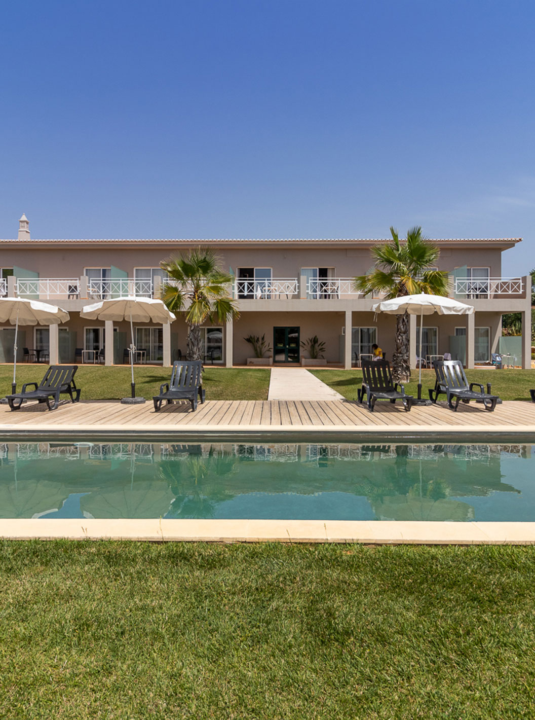 Chambre Classique au Pestana Gramacho Residences avec piscine, transats et parasols dans un jardin soigné
