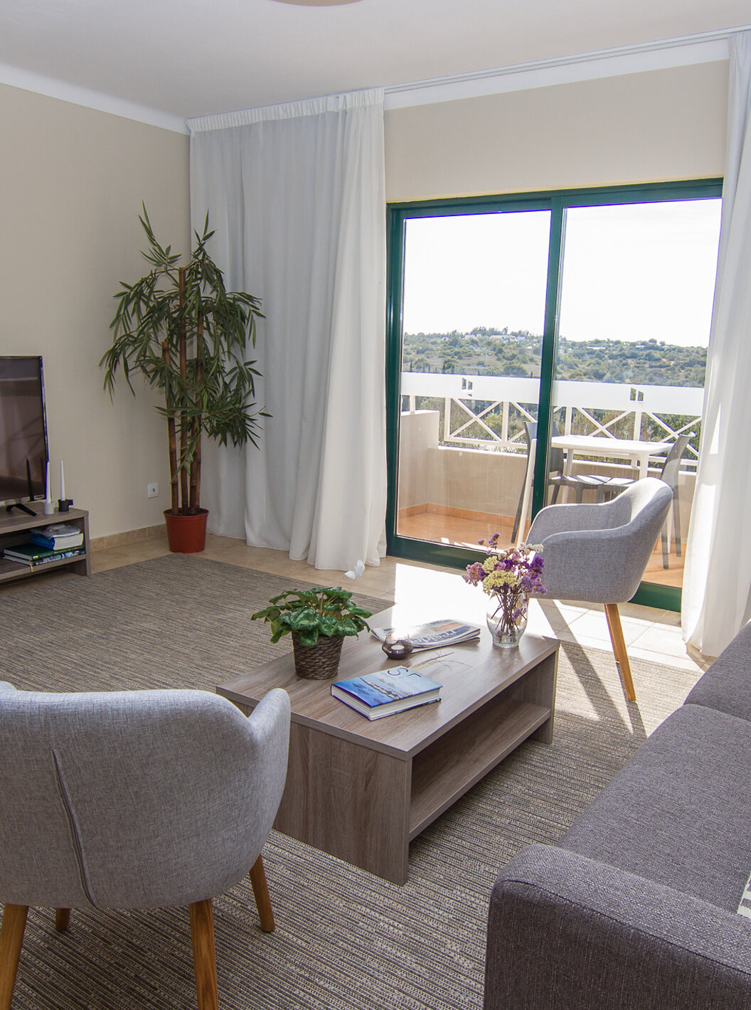 La Villa V3 du Pestana Gramacho Residences a un salon avec canapés, télévision et une fenêtre avec balcon