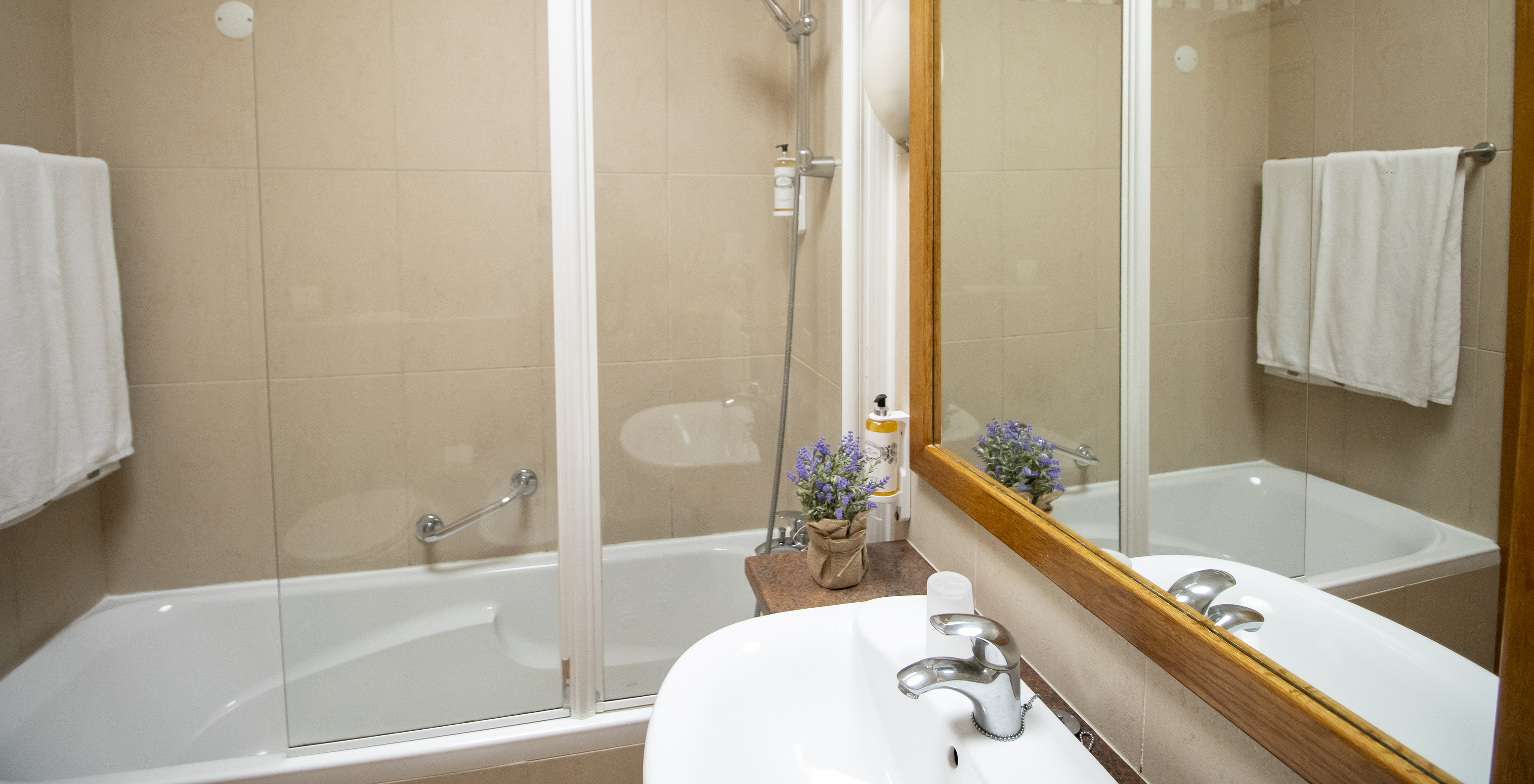 L'Appartement T2 Standard du Pestana Palm Gardens a une baignoire avec douche, serviettes et un lavabo