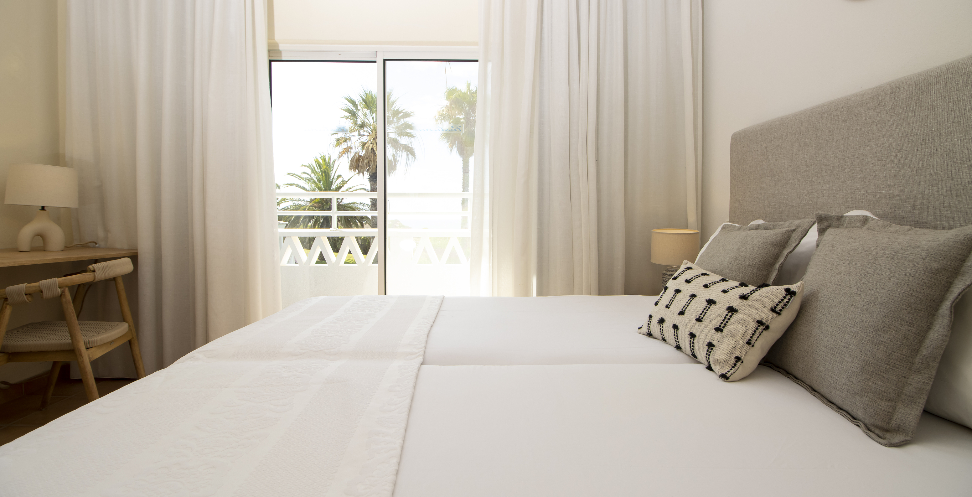 L'Appartement T2 Supérieur du Pestana Palm Gardens a un lit avec coussins, une fenêtre donnant accès à un balcon