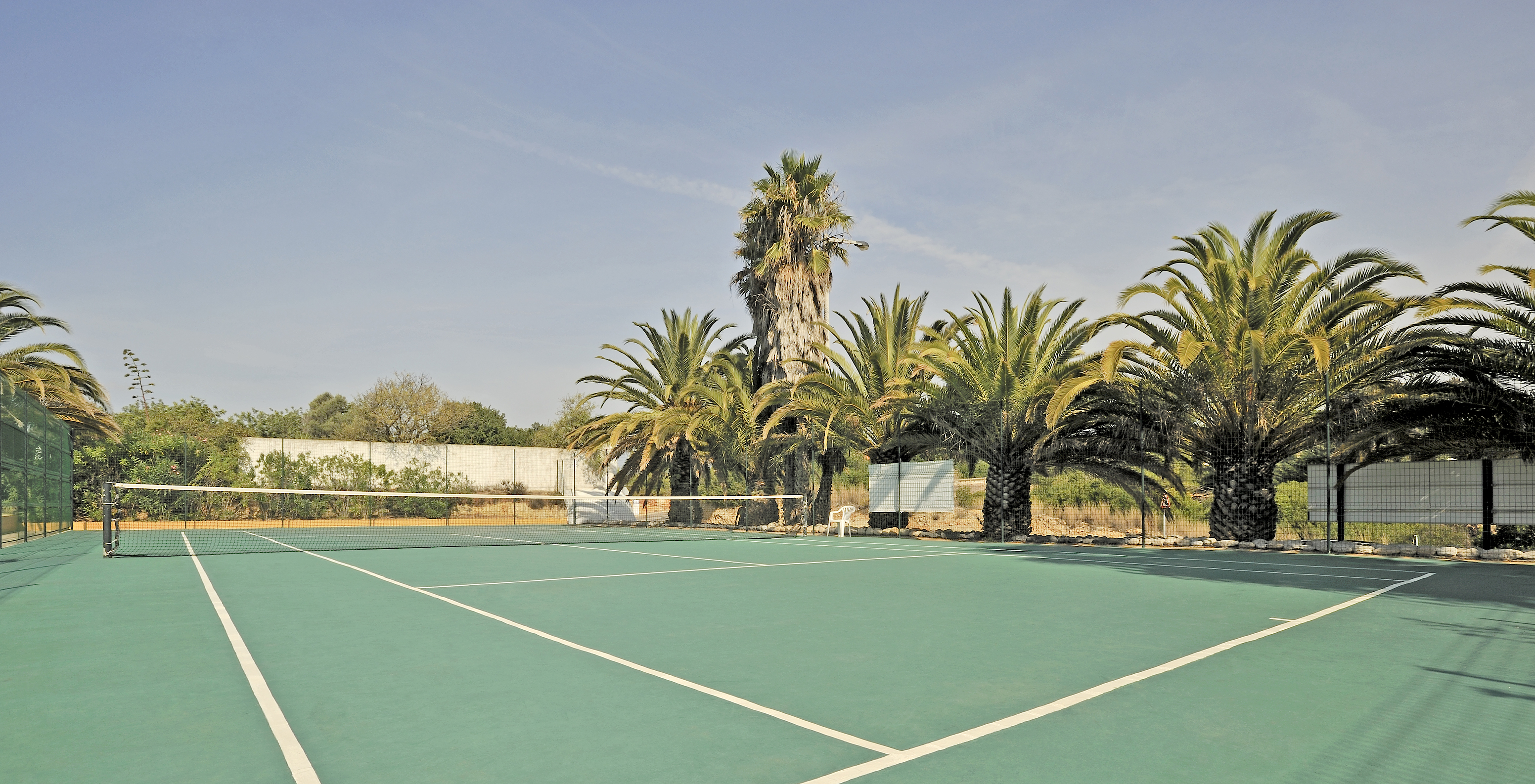 Court de tennis en dur au Pestana Palm Gardens, entouré de palmiers