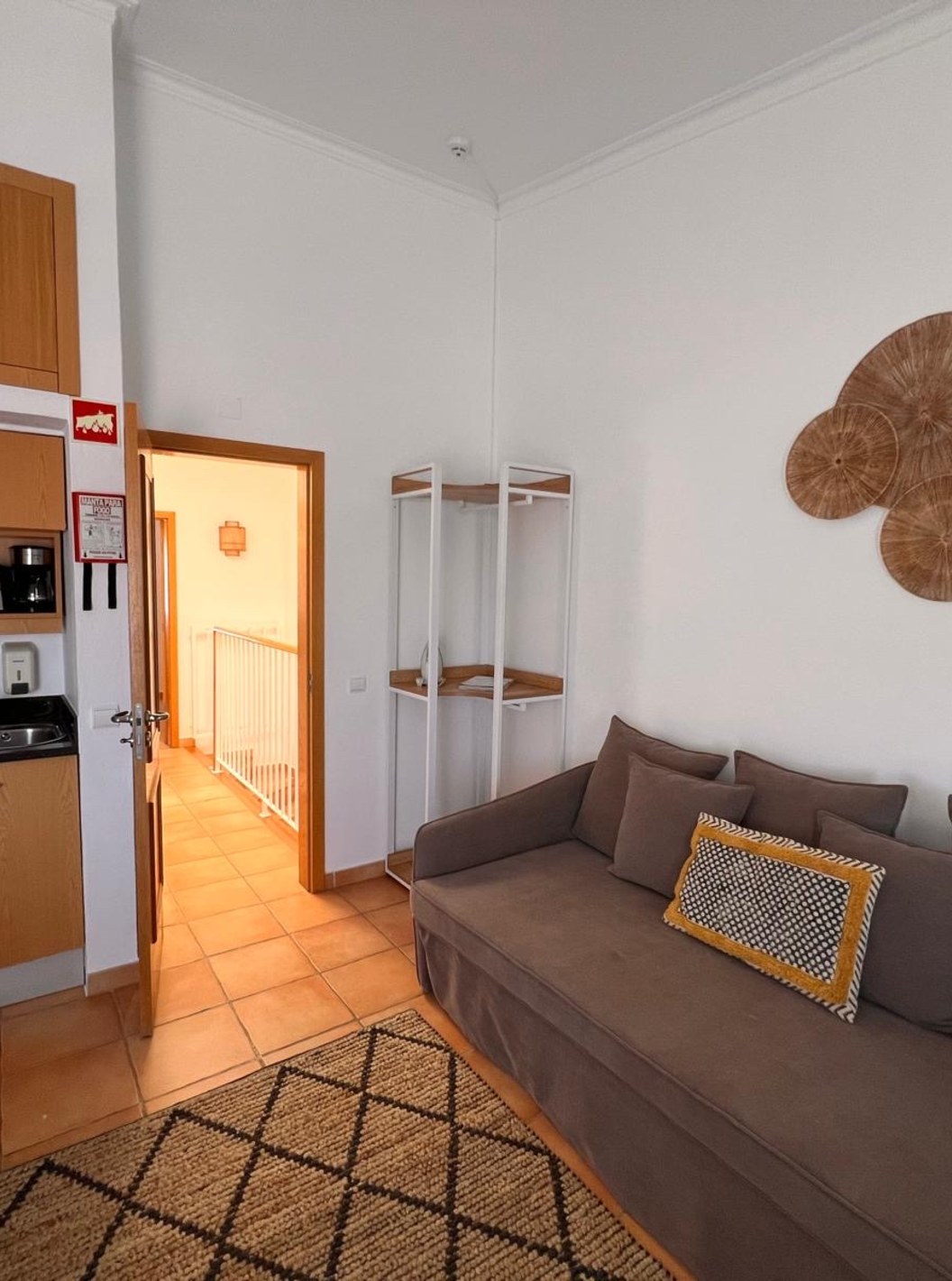 Appartement T1 Standard du Pestana Palm Gardens avec canapé gris, kitchenette en bois et décoration murale