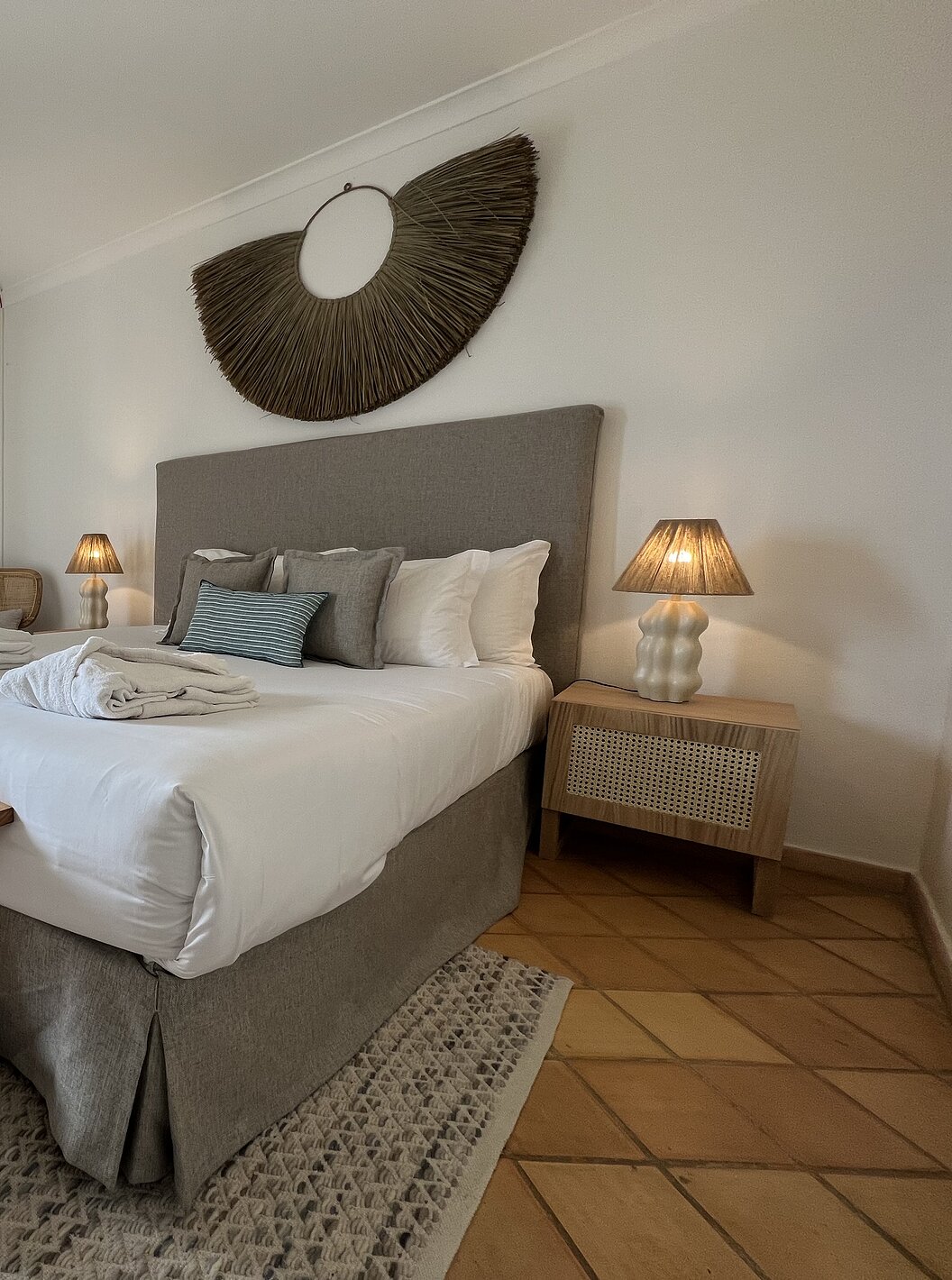 L'Appartement T2 Premium du Pestana Palm Gardens a un lit avec deux peignoirs, coussins et une fenêtre avec balcon